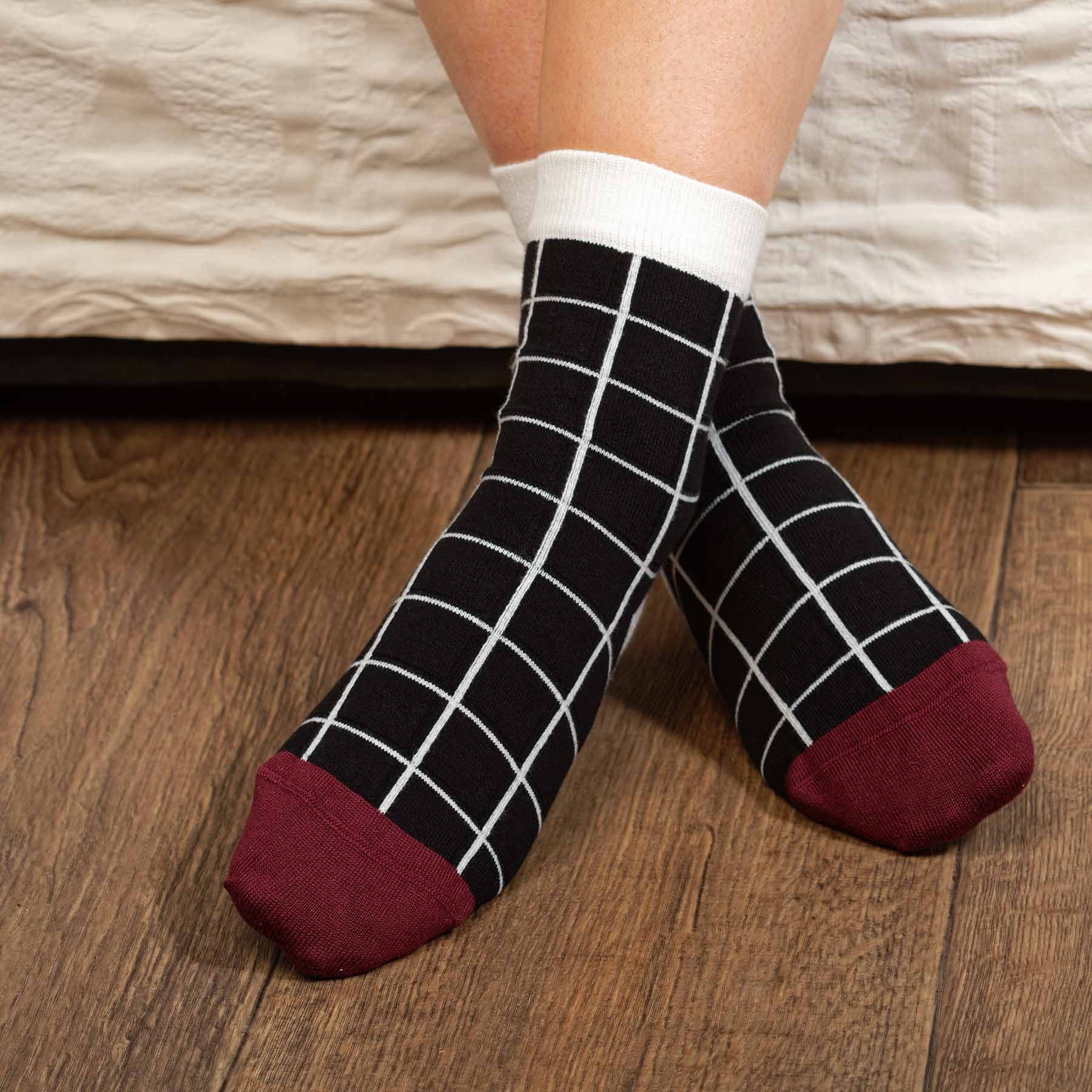 A pair of elegant black Grid Women's Socks featuring a symmetrical grid design, made from luxurious Supima cotton.