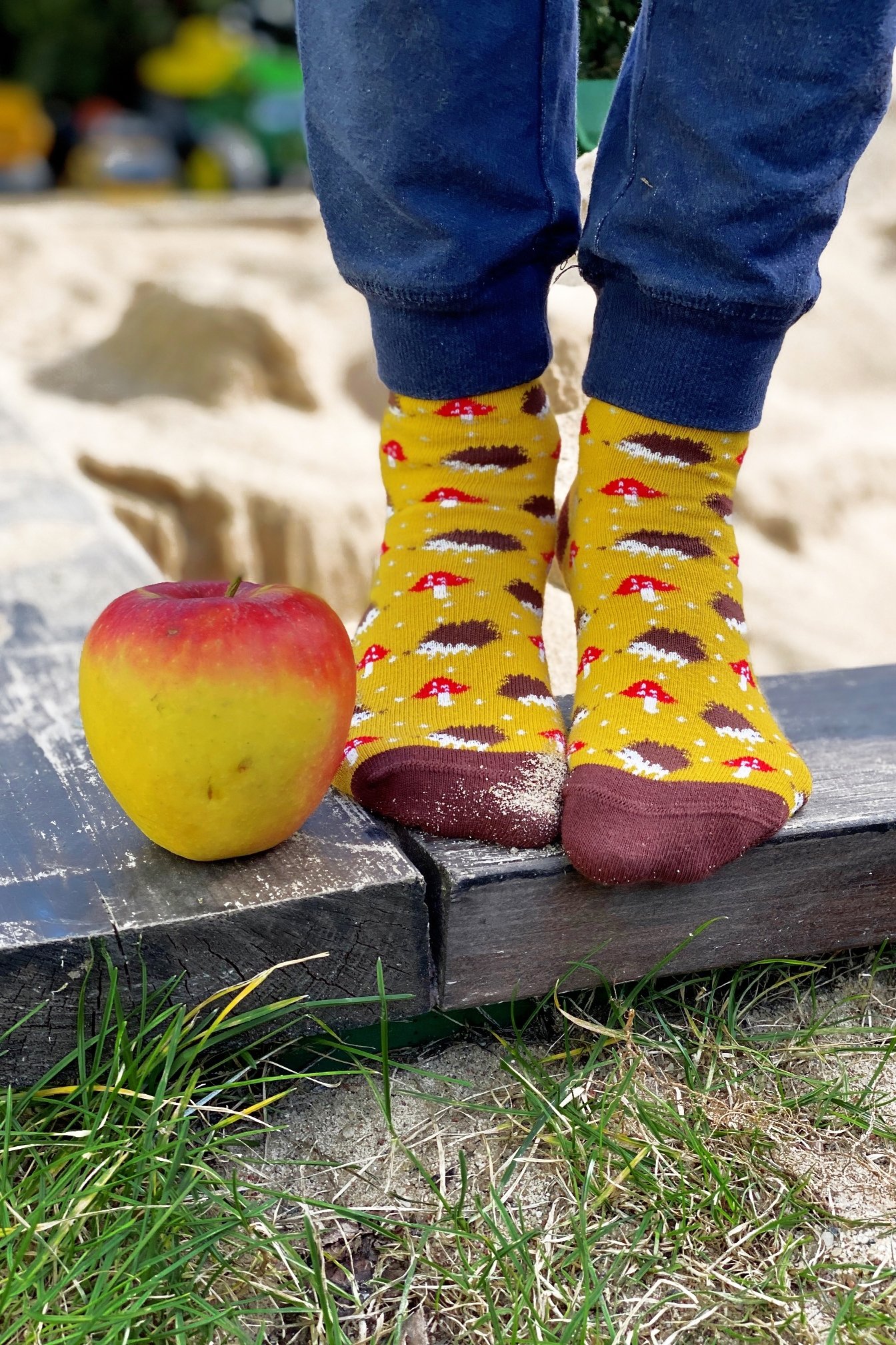 A pair of yellow cotton socks for children featuring a cute knitted hedgehog pattern, perfect for comfort and style.