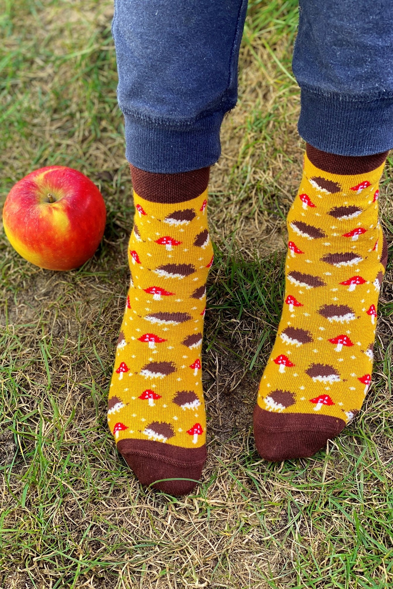 A pair of yellow cotton socks for children featuring a cute knitted hedgehog pattern, perfect for comfort and style.