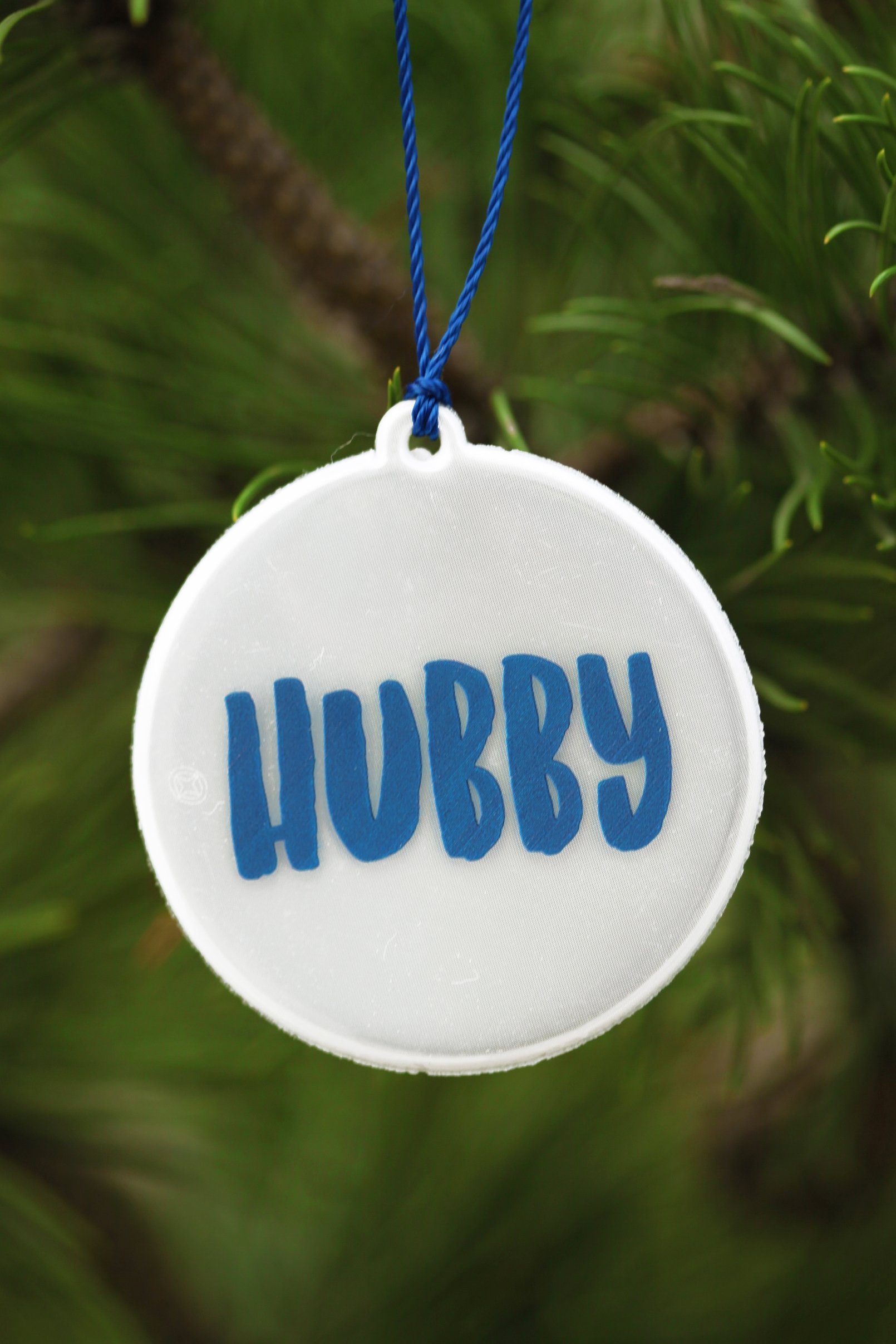 HUBBY reflector with blue writing, 60mm diameter, attached to a string.