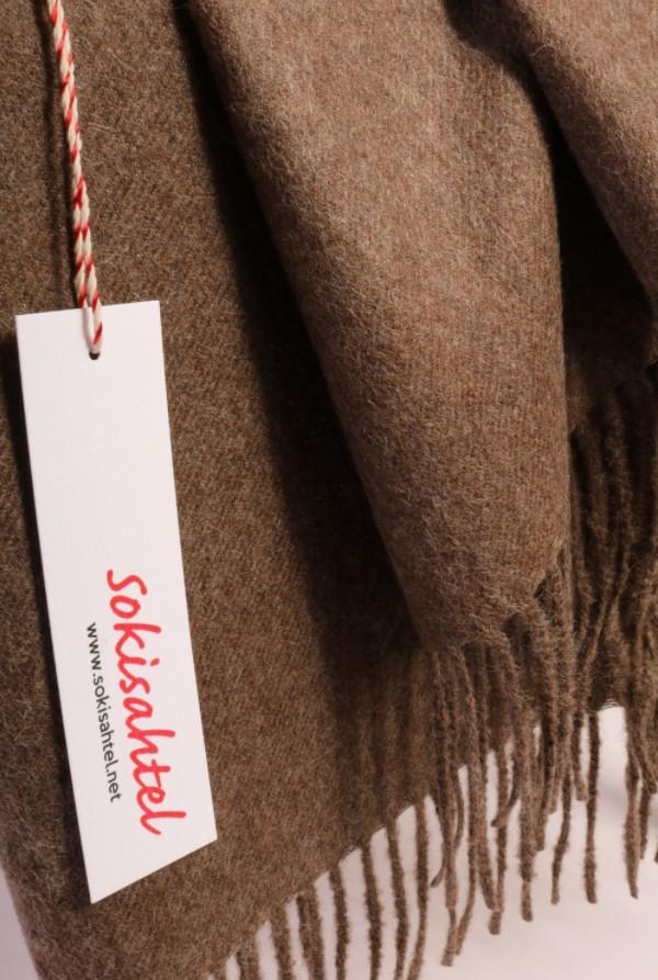 Light brown alpaca wool plaid draped elegantly, showcasing its luxurious texture and color.