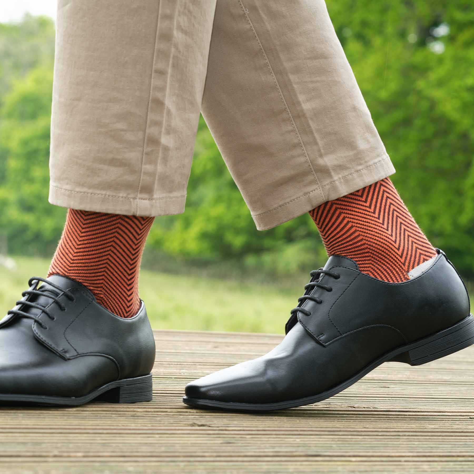 Lux Taylor Men's Socks in vibrant orange with black zigzag pattern and cream heel and toe, showcasing luxury and style.