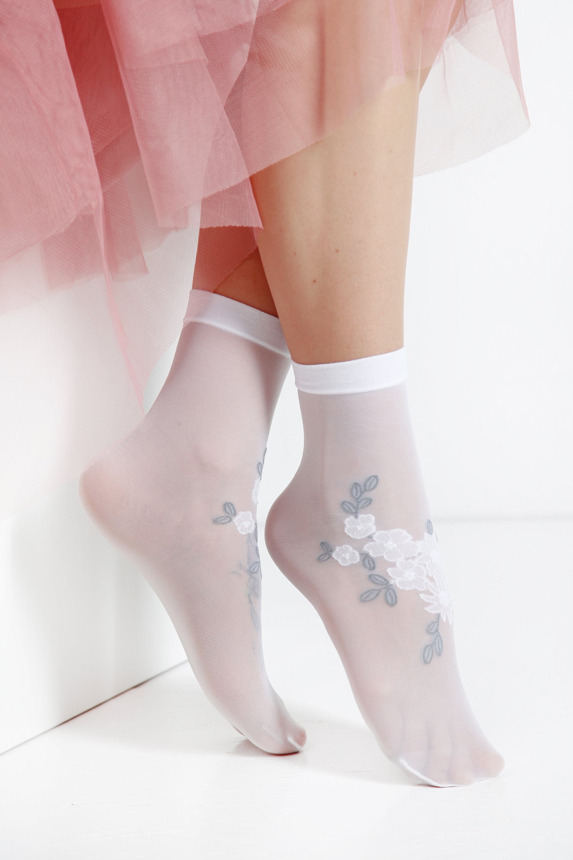 MATILDE sheer white socks for women featuring an elegant floral pattern, made from soft polyamide and elastane.