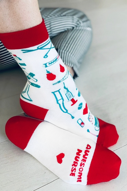 A pair of white cotton socks with 'Awesome nurse ♥' printed on the sole, designed for medical professionals.