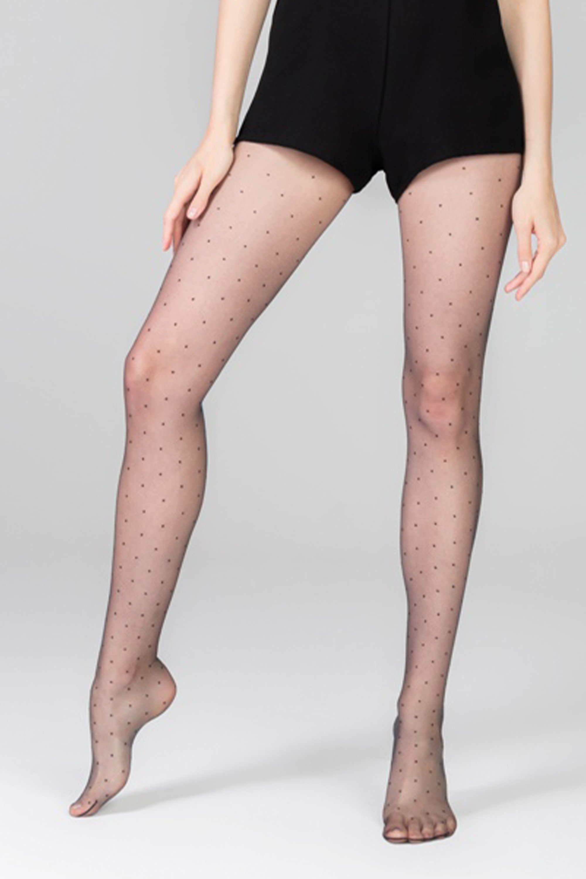 A pair of elegant black polka dot tights featuring a stylish design and unreinforced toe section, perfect for women.