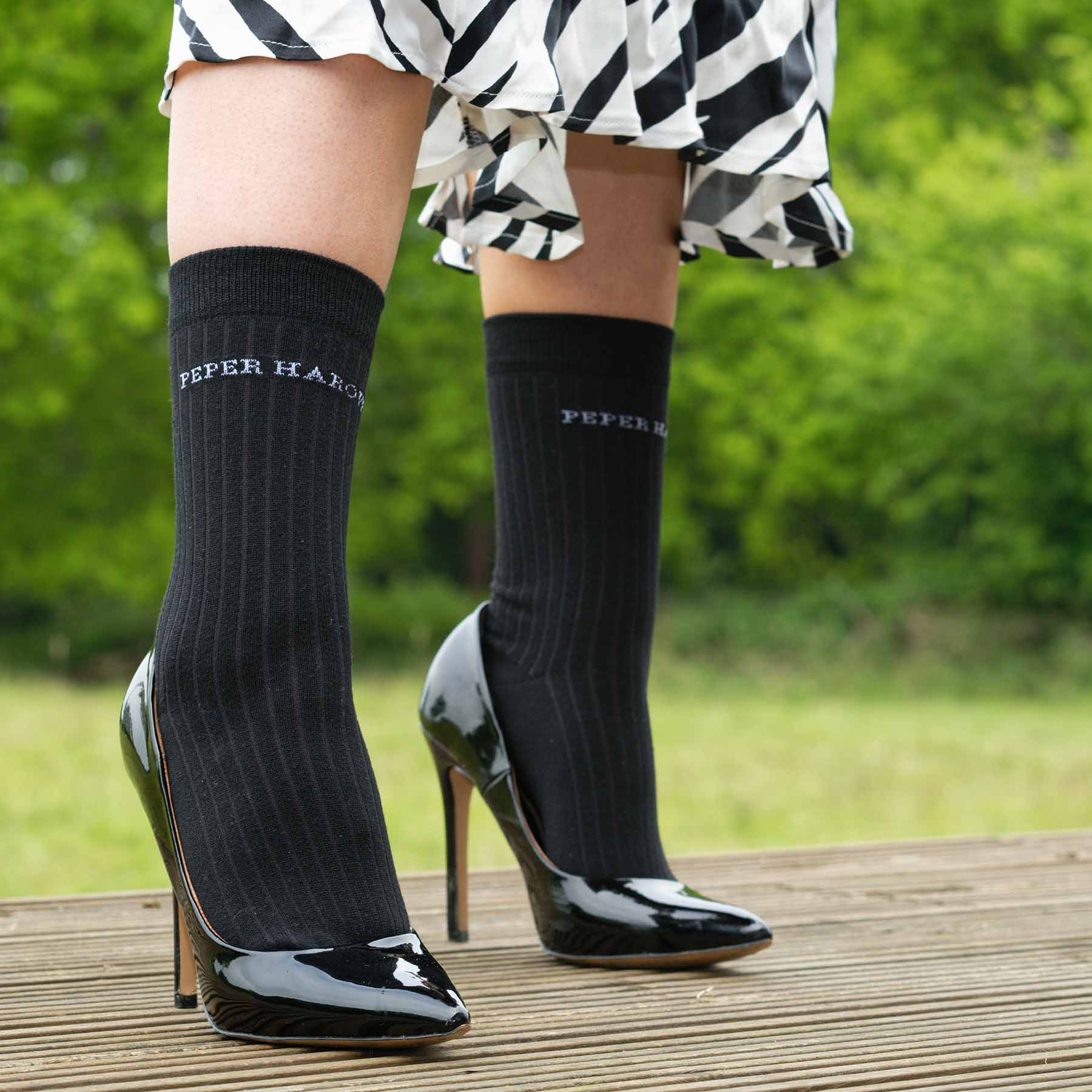 A pair of black ribbed women's socks made from recycled materials, showcasing their eco-friendly design and seamless toe.