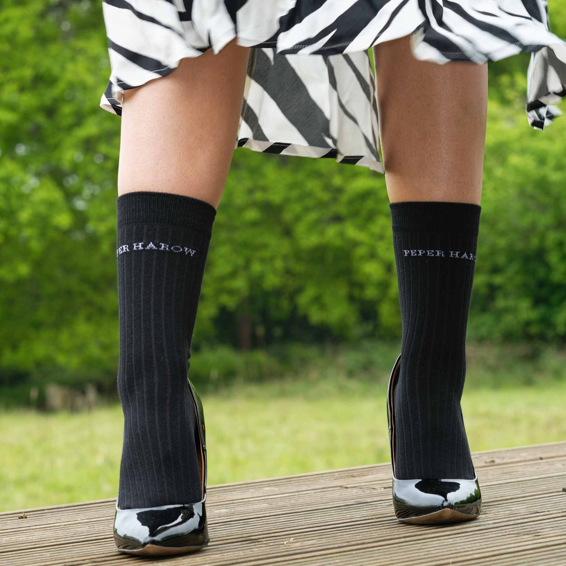 A pair of black ribbed women's socks made from recycled materials, showcasing their eco-friendly design and seamless toe.