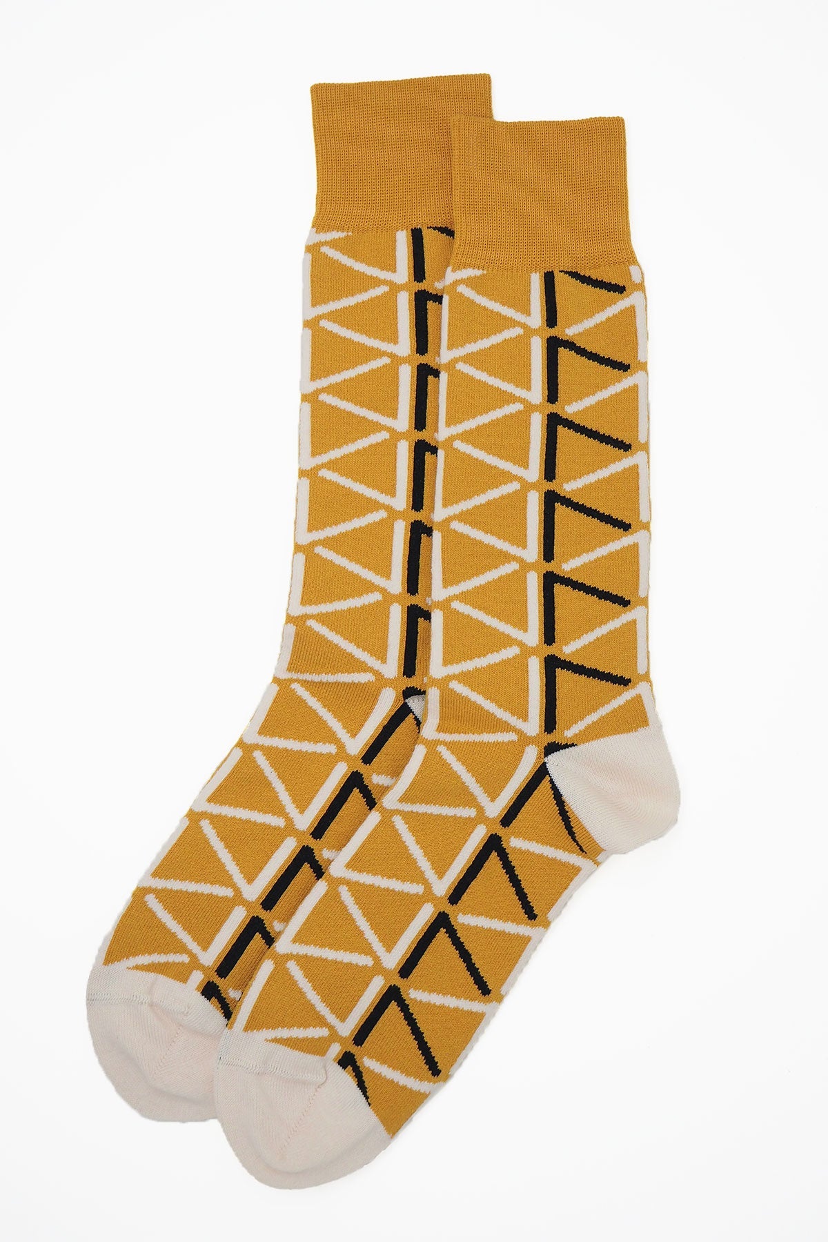 A pair of stylish mustard socks for men featuring contrasting black and cream patterns, made from luxurious Supima cotton.