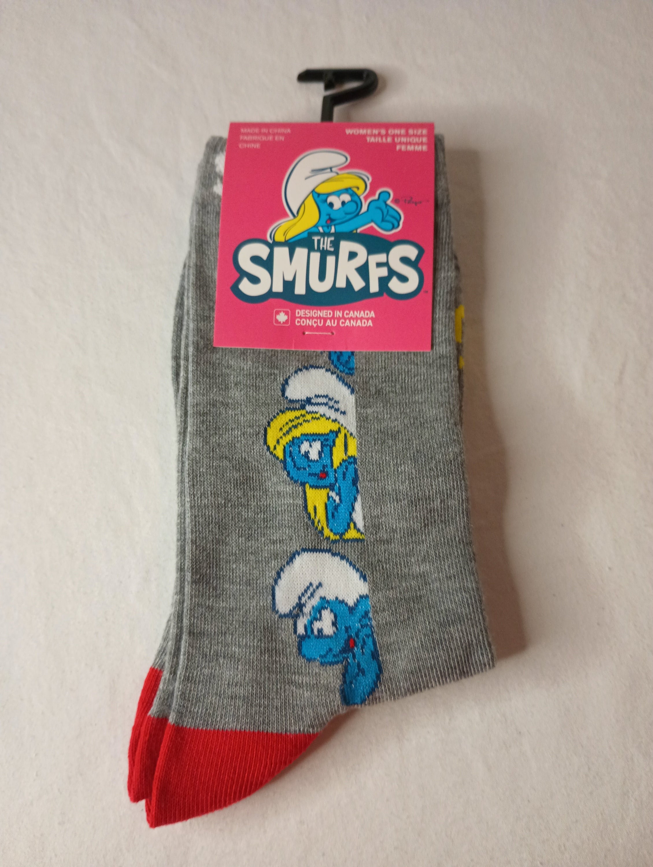 A pair of grey crew socks featuring colorful SMURFS designs, suitable for women's shoe sizes 6-9.5.