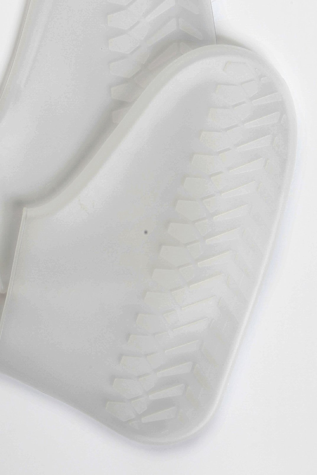 White waterproof shoe covers made of silicone, designed to protect shoes from rain and mud with an anti-slip sole.