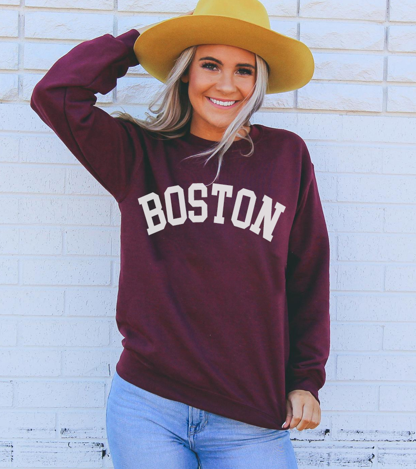 A cozy Boston Sweatshirt featuring a crew neck, made from soft air-jet spun yarn, perfect for casual wear.