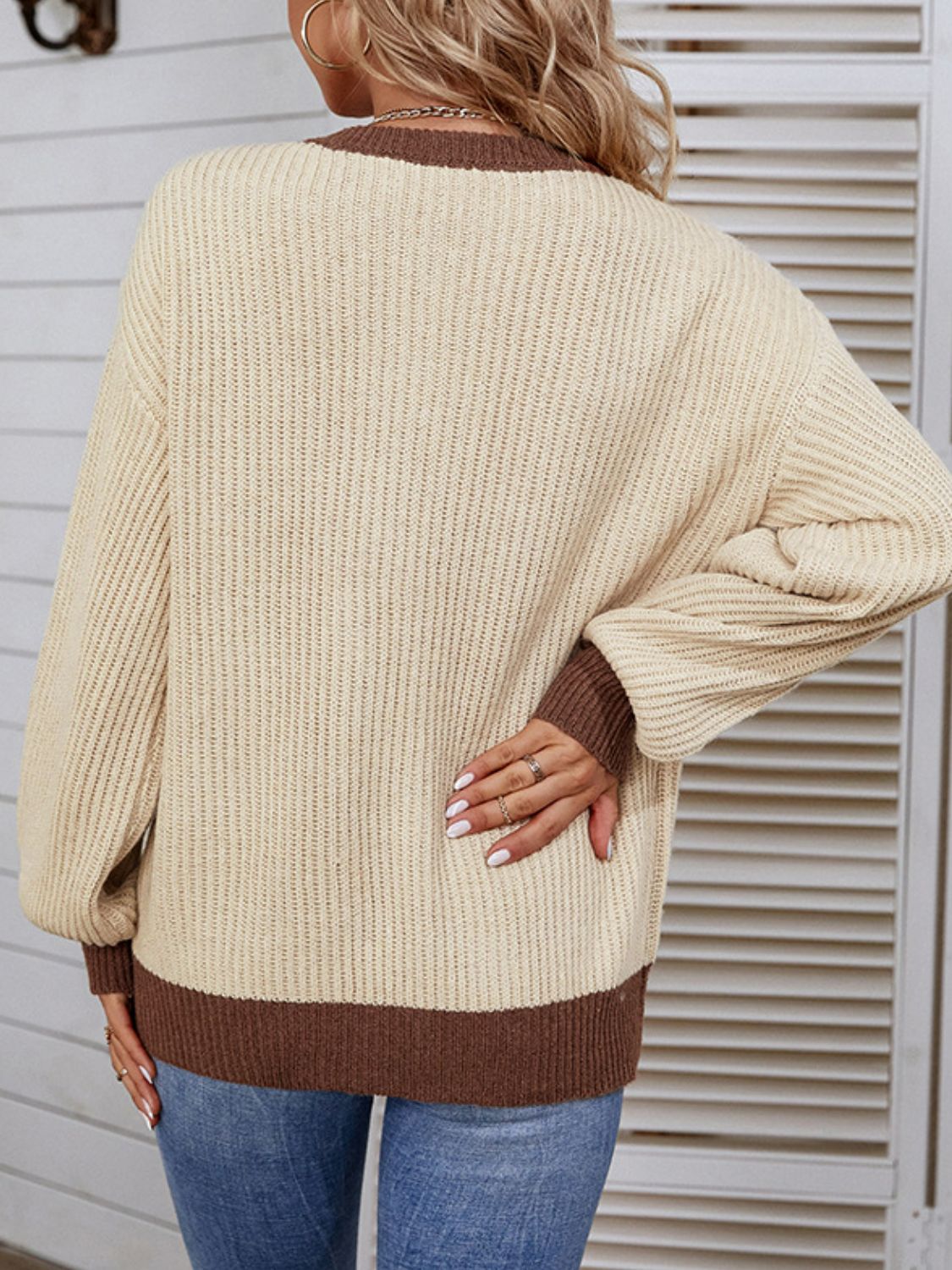 A stylish Contrast Button Detail Rib-Knit Sweater featuring a ribbed texture, round neck, and lantern sleeves, available in multiple colors.