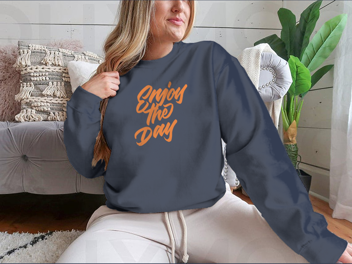 A stylish shirt featuring modern handwritten calligraphy that says 'Enjoy The Day', made from soft cotton fabric.