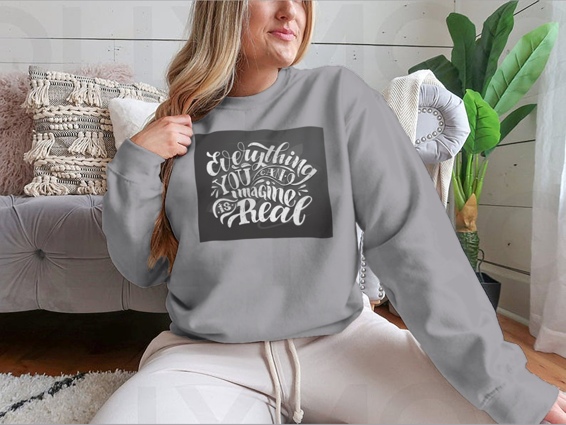 A cute hand-drawn doodle T-shirt featuring the motivational phrase 'Everything You Can Imagine Is Real' on a soft cotton fabric.