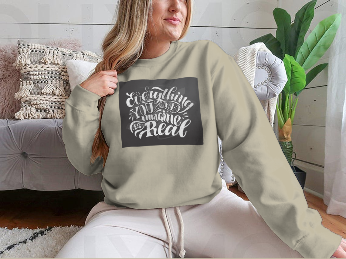 A cute hand-drawn doodle T-shirt featuring the motivational phrase 'Everything You Can Imagine Is Real' on a soft cotton fabric.