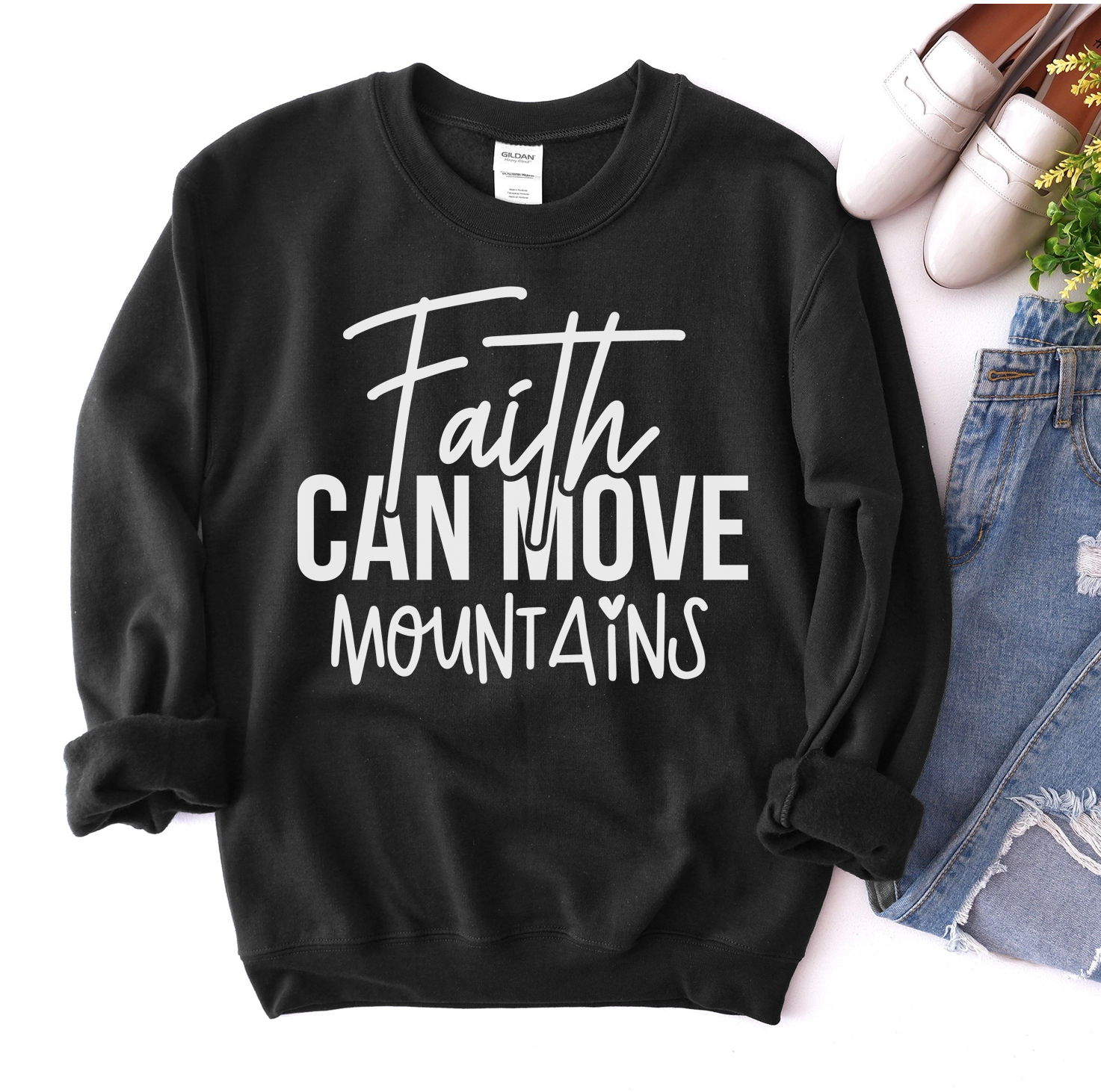 A cozy unisex sweatshirt featuring the phrase 'Faith Can Move Mountains' in stylish lettering, perfect for casual wear.