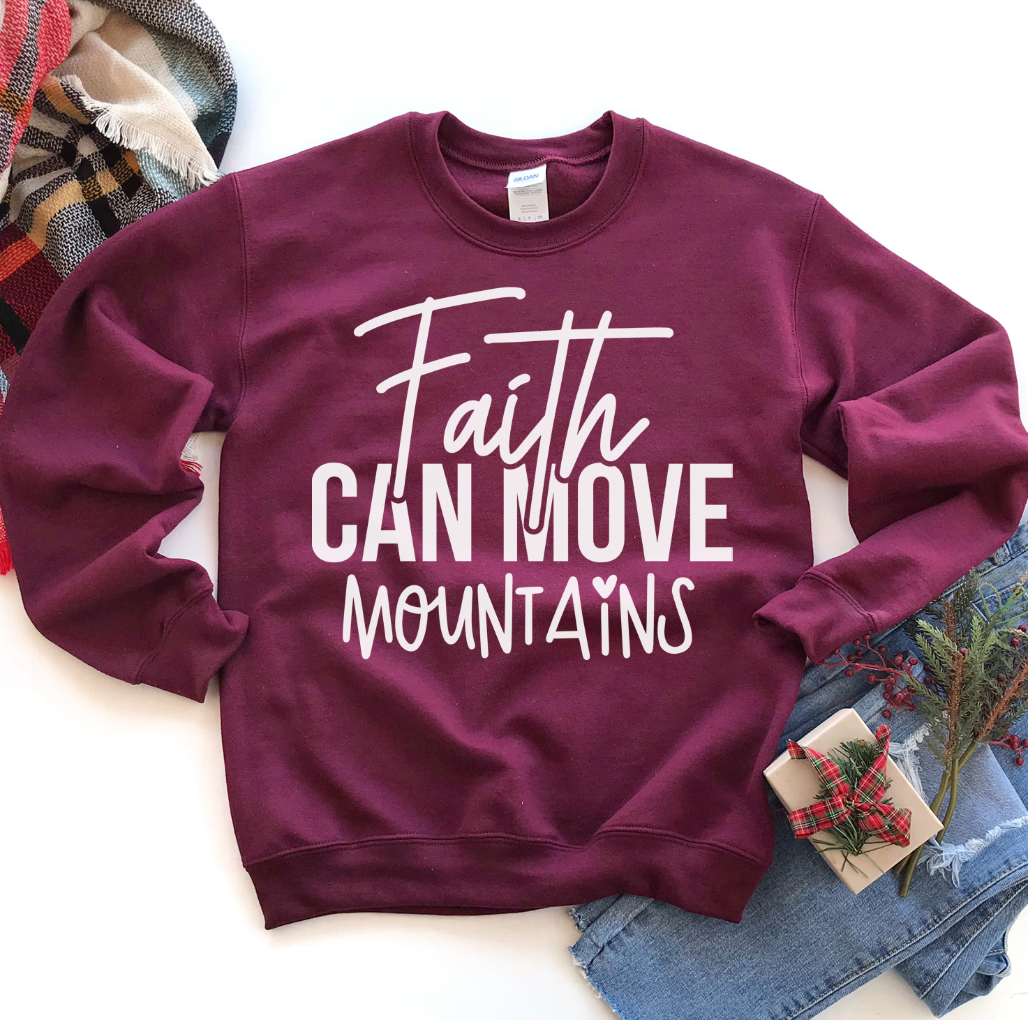 A cozy unisex sweatshirt featuring the phrase 'Faith Can Move Mountains' in stylish lettering, perfect for casual wear.