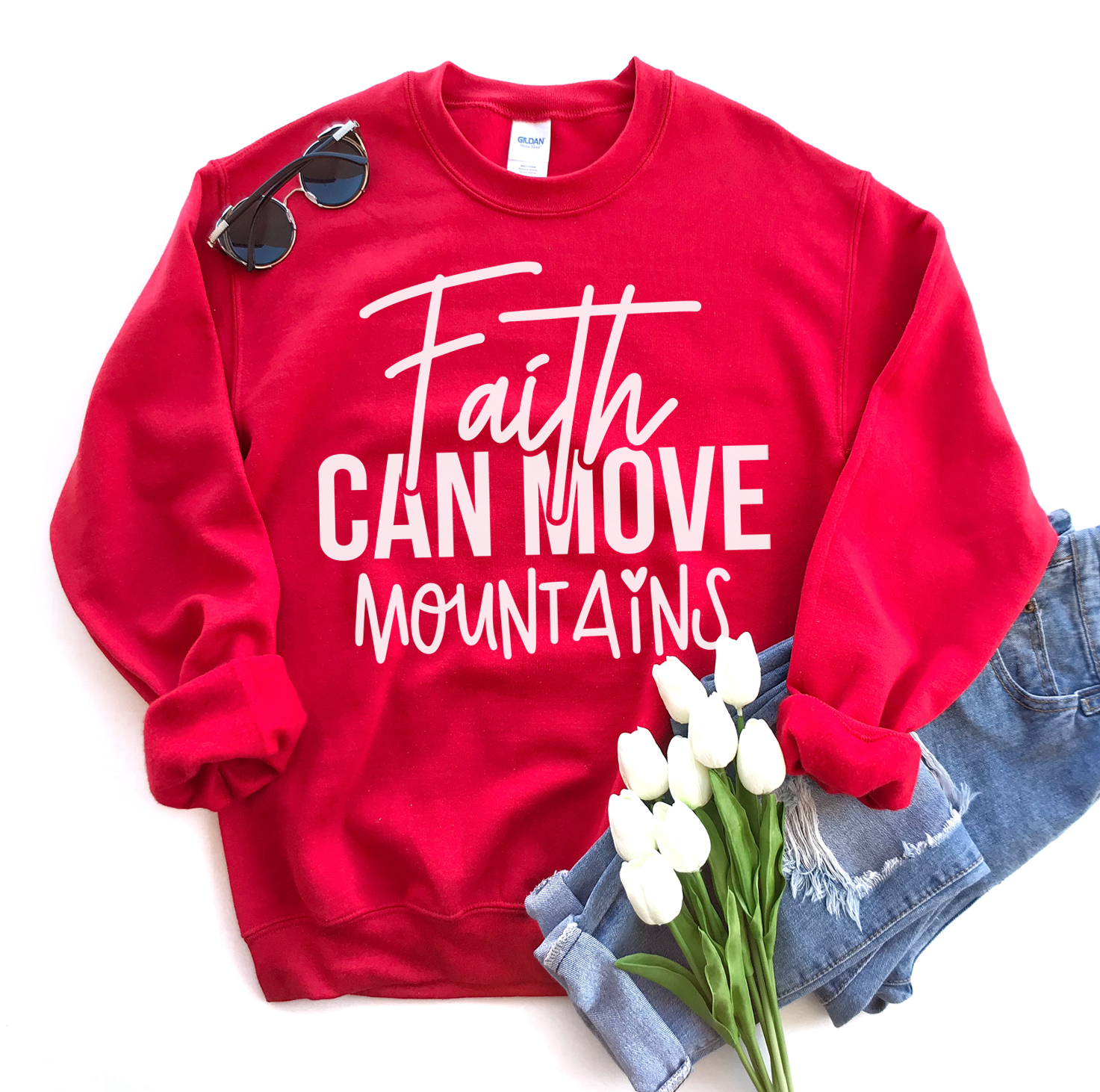 A cozy unisex sweatshirt featuring the phrase 'Faith Can Move Mountains' in stylish lettering, perfect for casual wear.