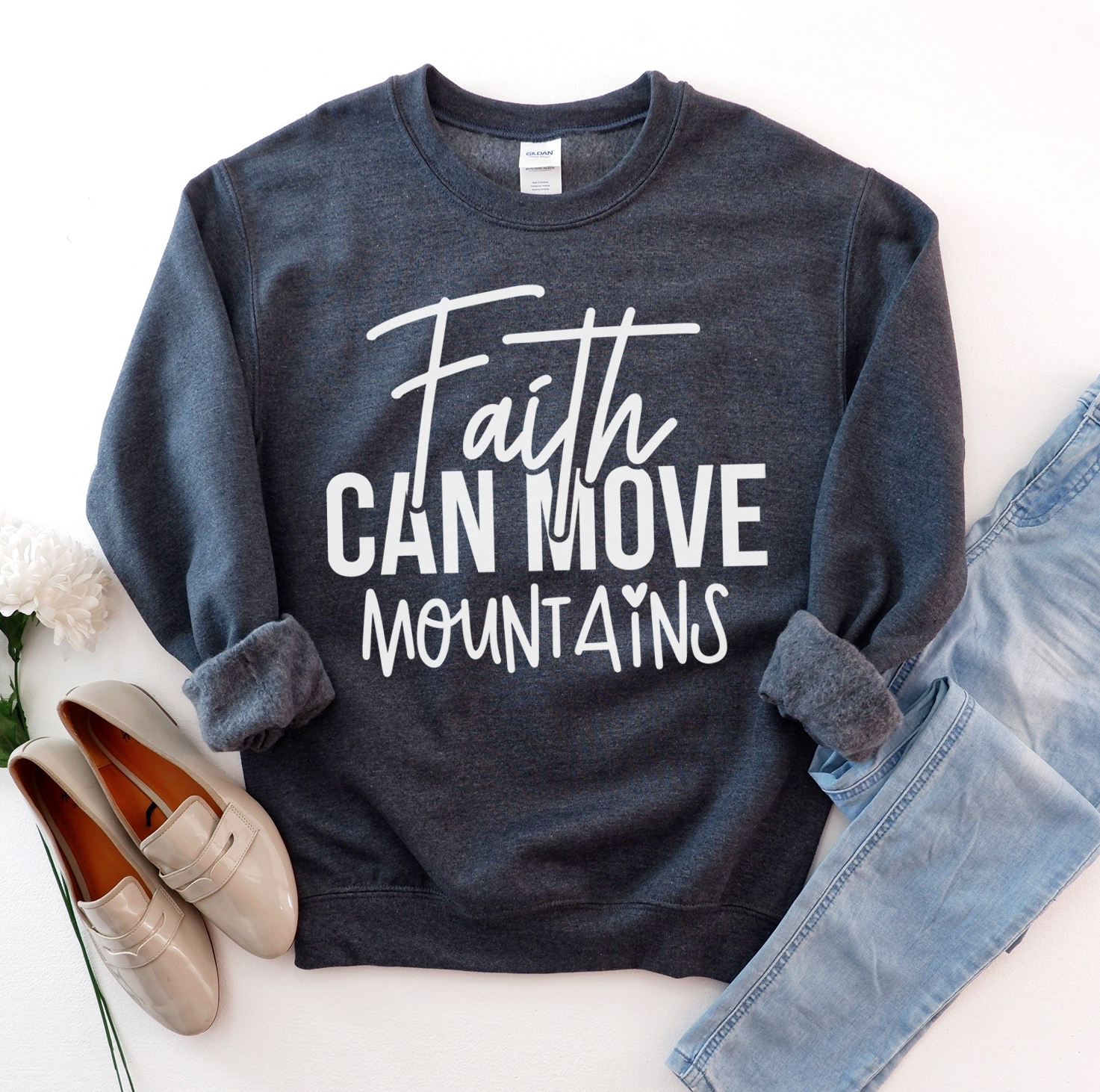 A cozy unisex sweatshirt featuring the phrase 'Faith Can Move Mountains' in stylish lettering, perfect for casual wear.