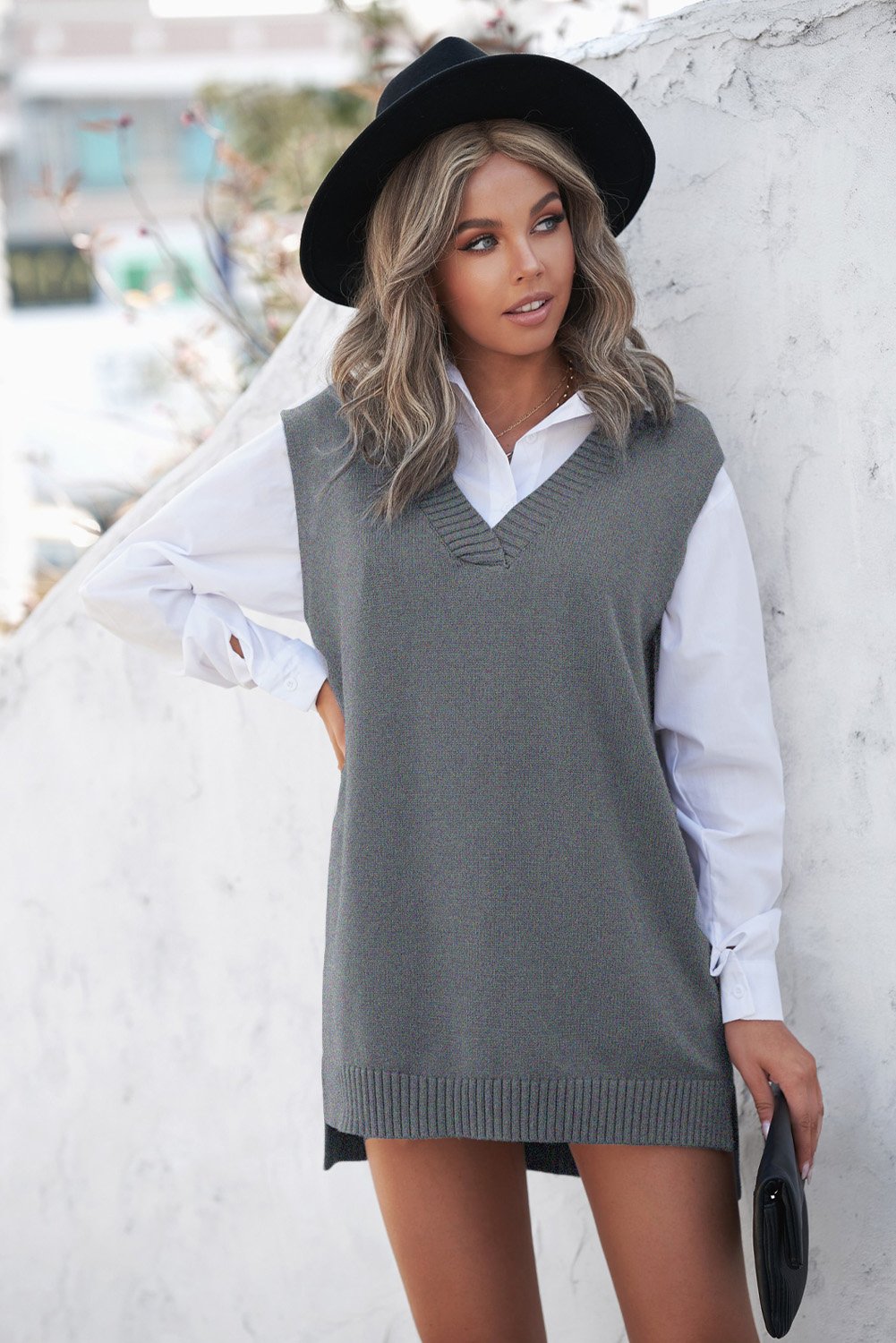 A stylish gray sweater vest featuring a v-neckline, sleeveless design, and high-low hemline, perfect for casual wear.