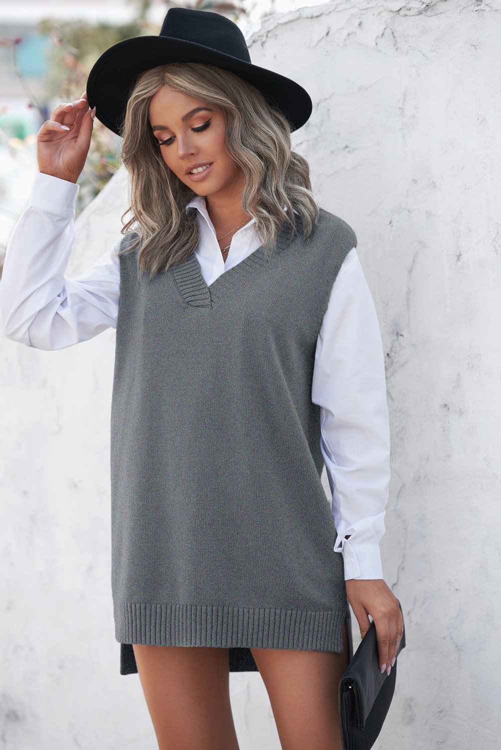 A stylish gray sweater vest featuring a v-neckline, sleeveless design, and high-low hemline, perfect for casual wear.