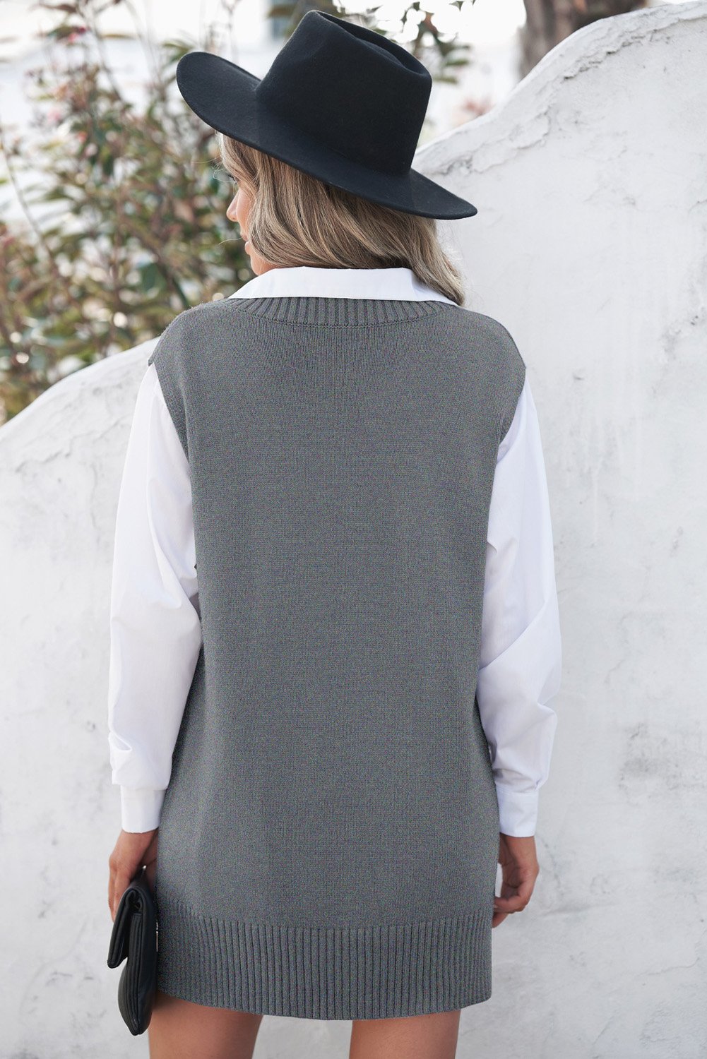 A stylish gray sweater vest featuring a v-neckline, sleeveless design, and high-low hemline, perfect for casual wear.