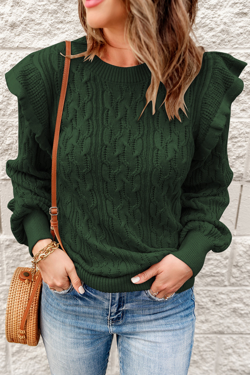 A stylish green cable knit sweater with feminine ruffles on the shoulders, showcasing ribbed details at the neckline, cuffs, and hemline.