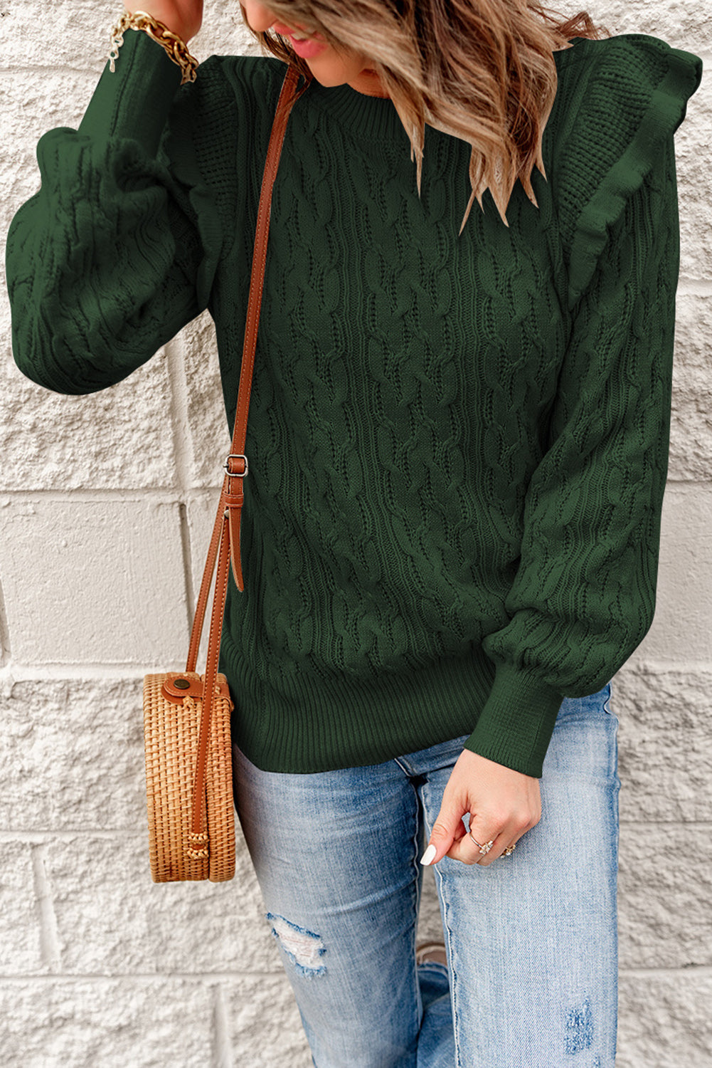 A stylish green cable knit sweater with feminine ruffles on the shoulders, showcasing ribbed details at the neckline, cuffs, and hemline.