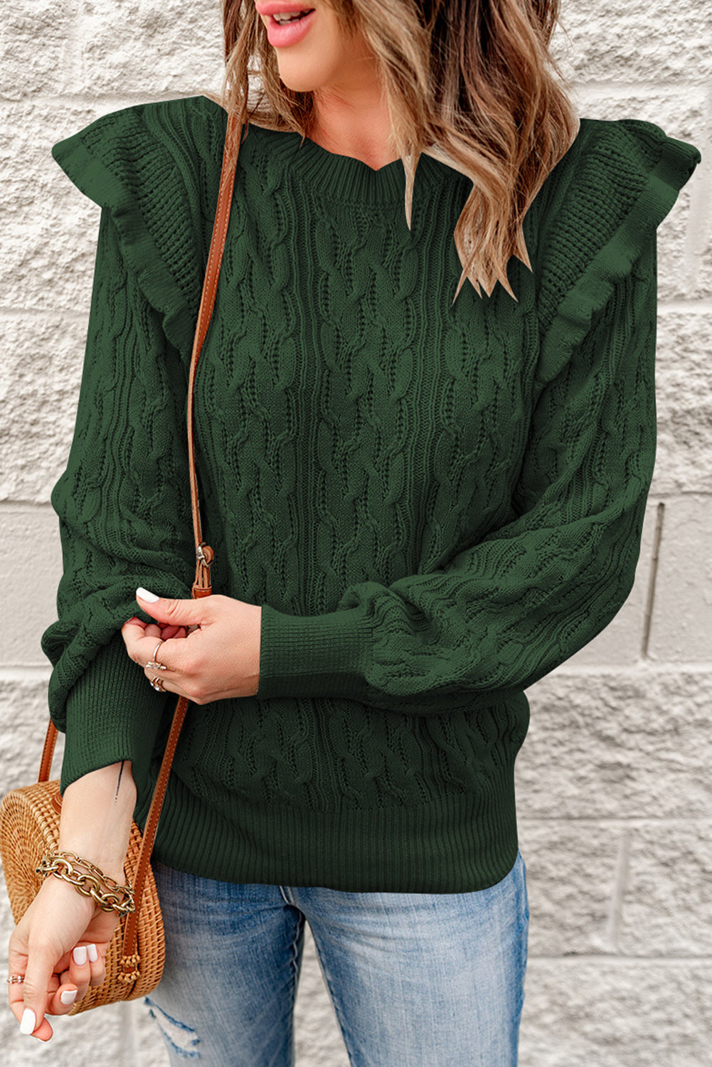 A stylish green cable knit sweater with feminine ruffles on the shoulders, showcasing ribbed details at the neckline, cuffs, and hemline.