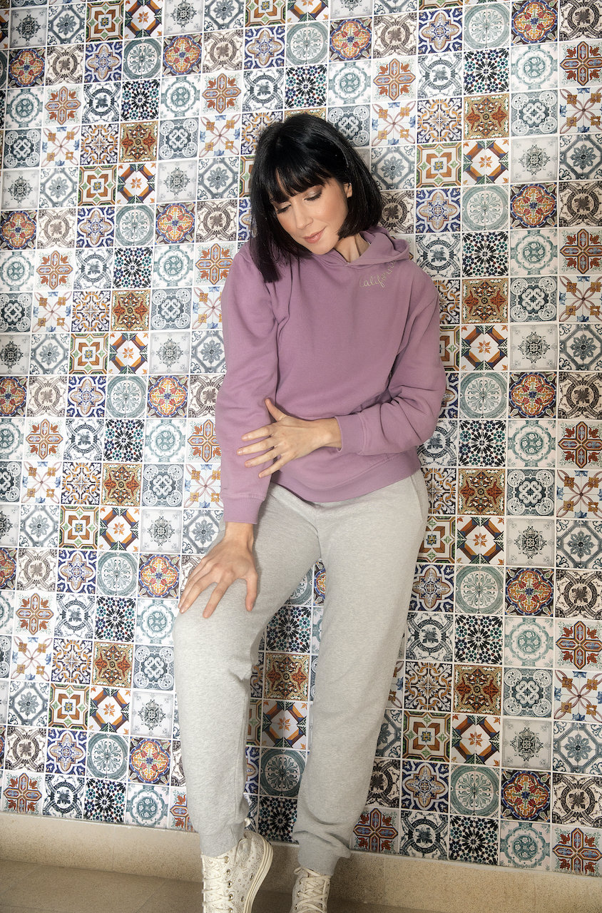 A stylish loose hoodie for women in orchid color, featuring long sleeves, ribbed cuffs, and an embroidered 'California' detail.