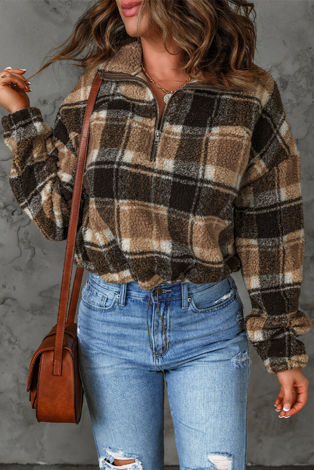 A stylish plaid pattern fleece sweatshirt featuring a cozy sherpa design, zip collar, and adjustable drawstring hem in brown color.