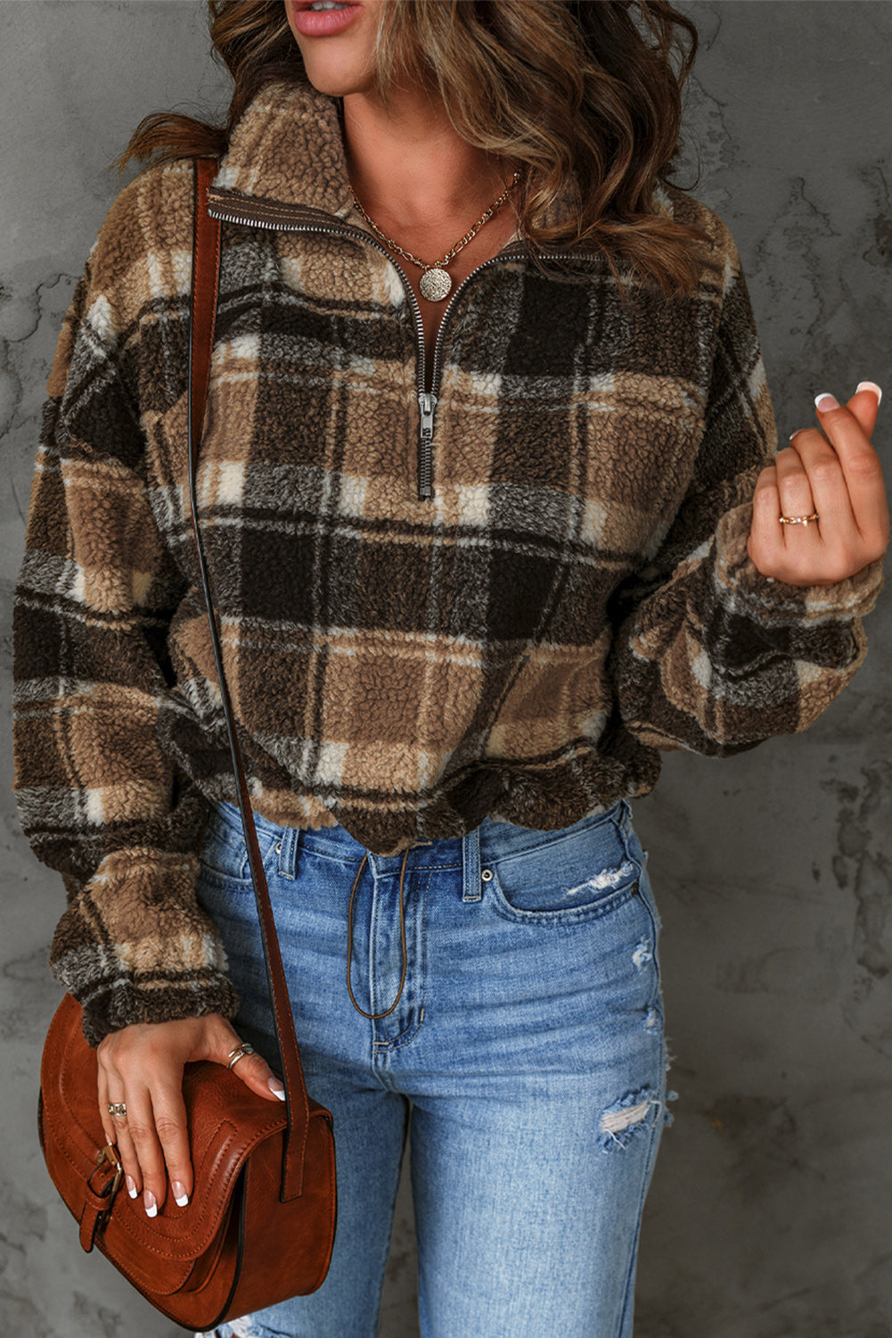 A stylish plaid pattern fleece sweatshirt featuring a cozy sherpa design, zip collar, and adjustable drawstring hem in brown color.