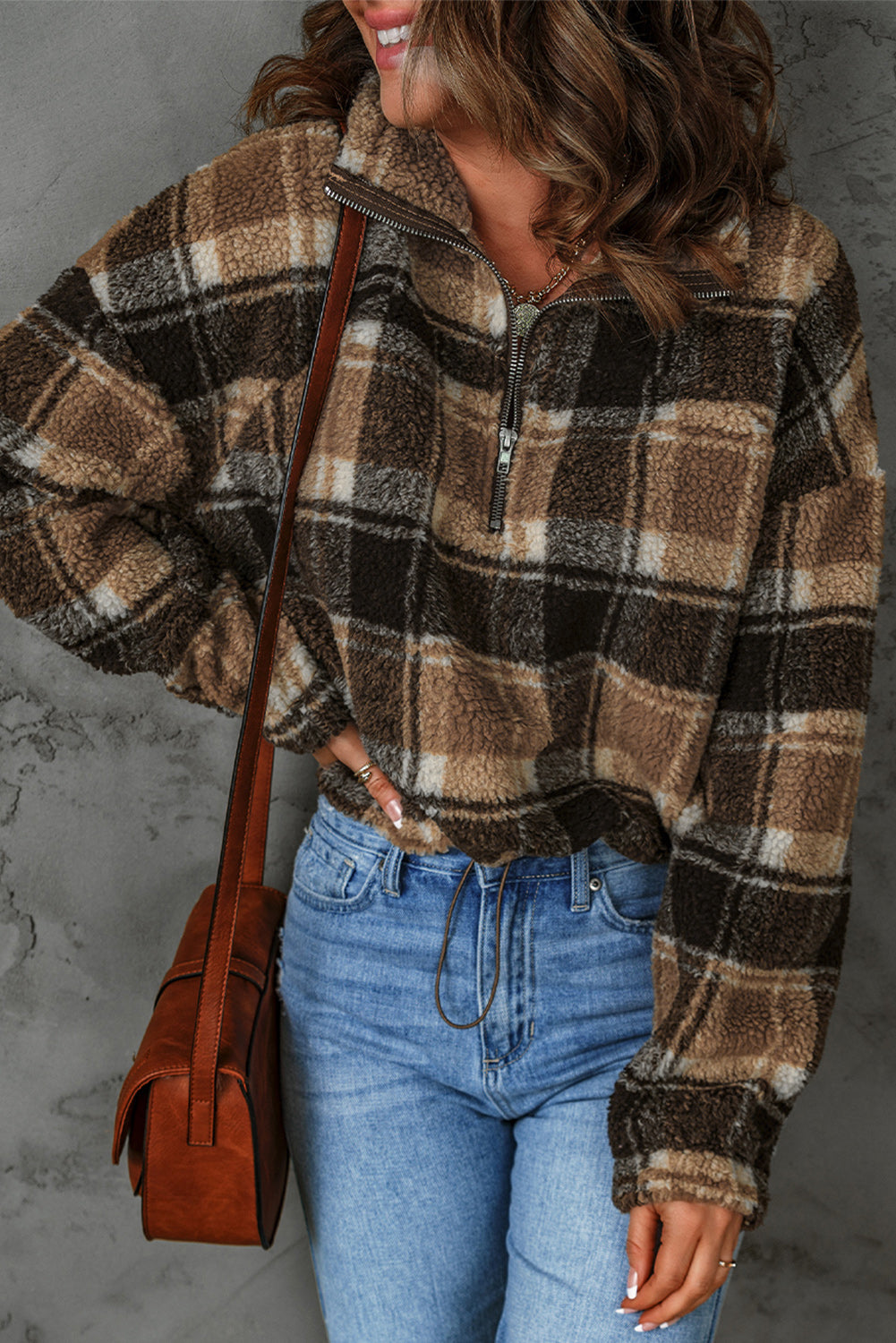 A stylish plaid pattern fleece sweatshirt featuring a cozy sherpa design, zip collar, and adjustable drawstring hem in brown color.