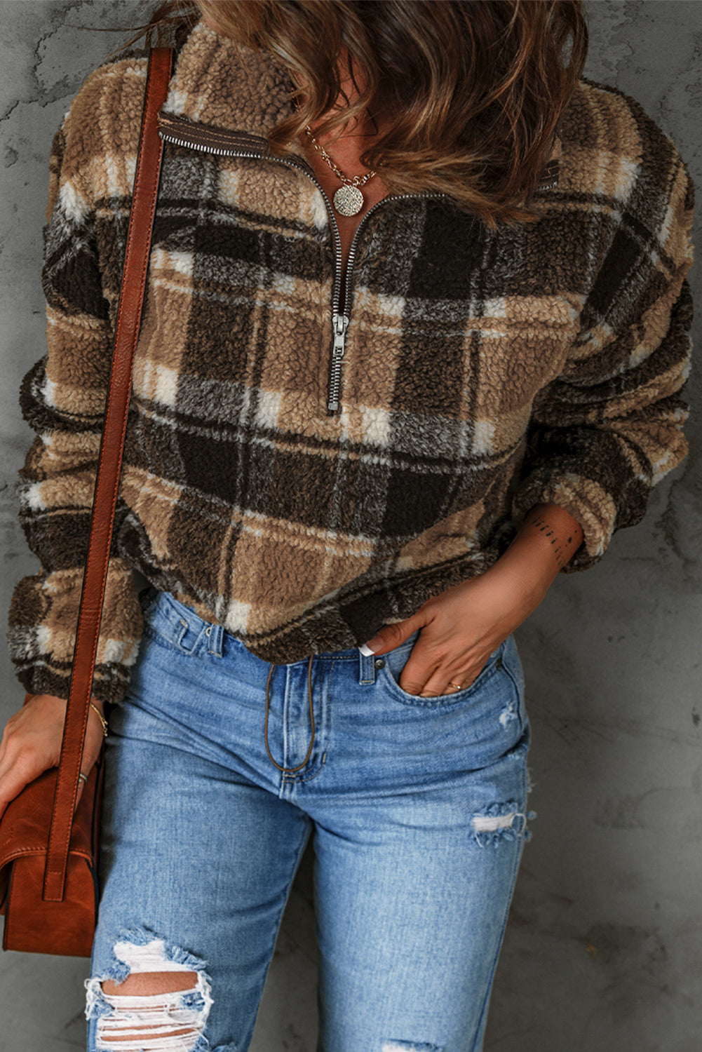 A stylish plaid pattern fleece sweatshirt featuring a cozy sherpa design, zip collar, and adjustable drawstring hem in brown color.