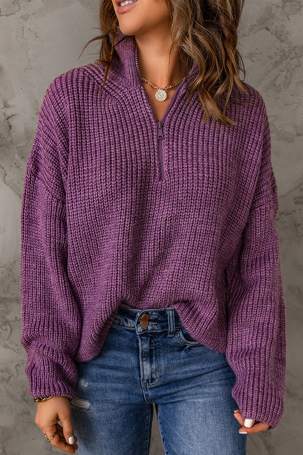 A cozy purple zipped turtleneck sweater displayed on a mannequin, showcasing its soft knitted texture and stylish design.