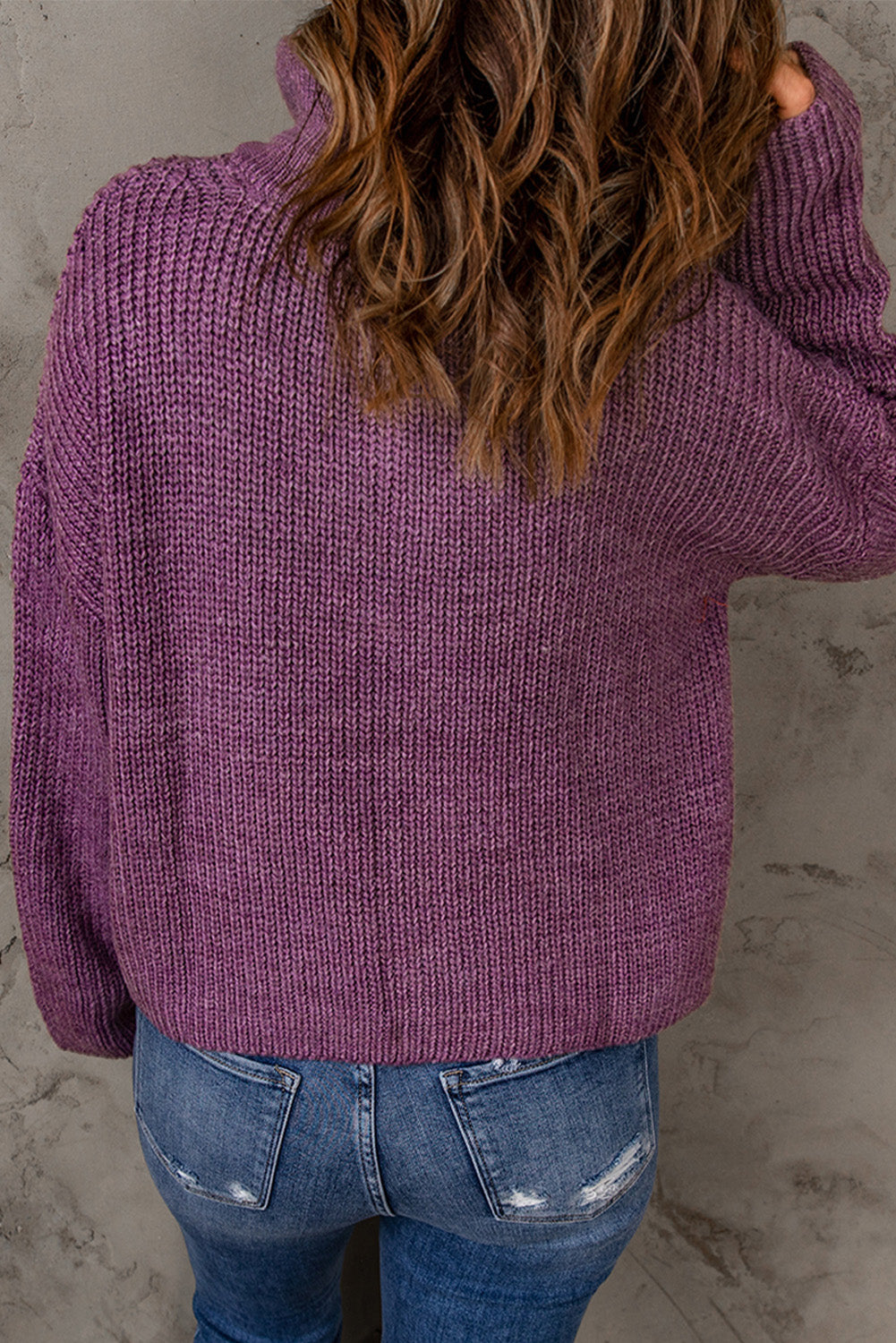 A cozy purple zipped turtleneck sweater displayed on a mannequin, showcasing its soft knitted texture and stylish design.