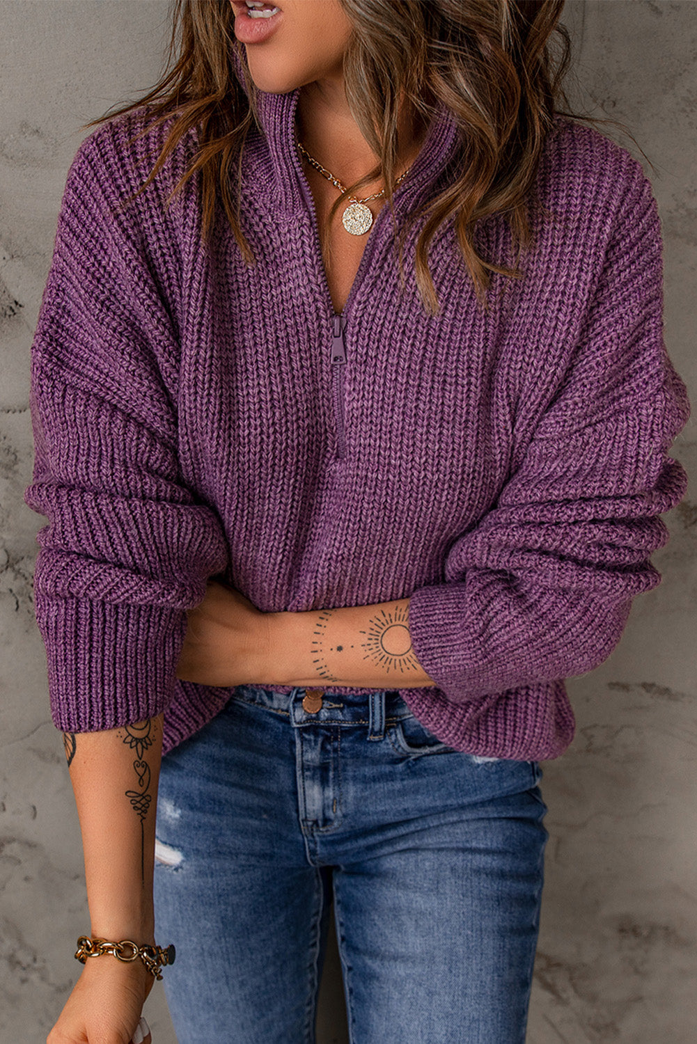 A cozy purple zipped turtleneck sweater displayed on a mannequin, showcasing its soft knitted texture and stylish design.