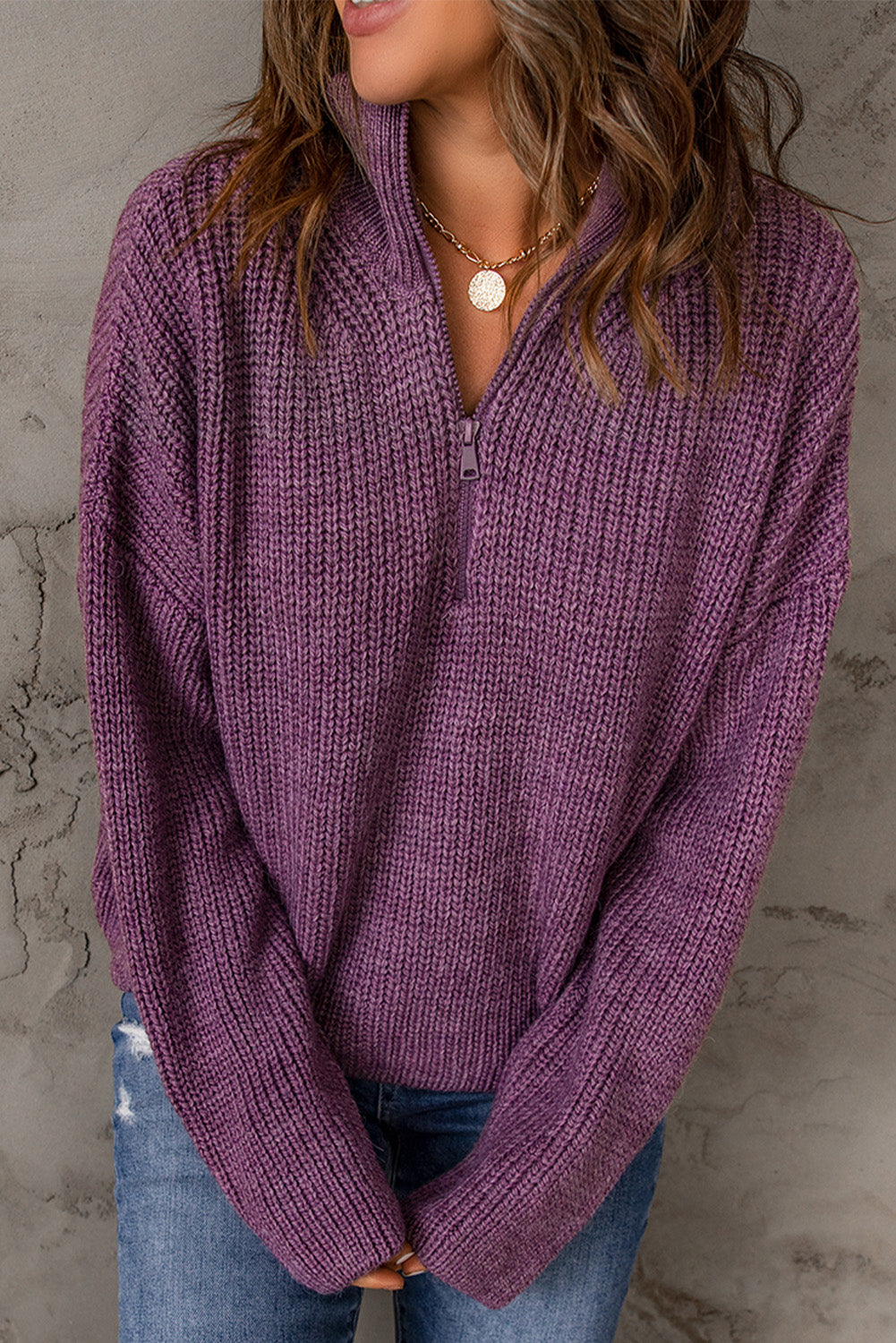 A cozy purple zipped turtleneck sweater displayed on a mannequin, showcasing its soft knitted texture and stylish design.