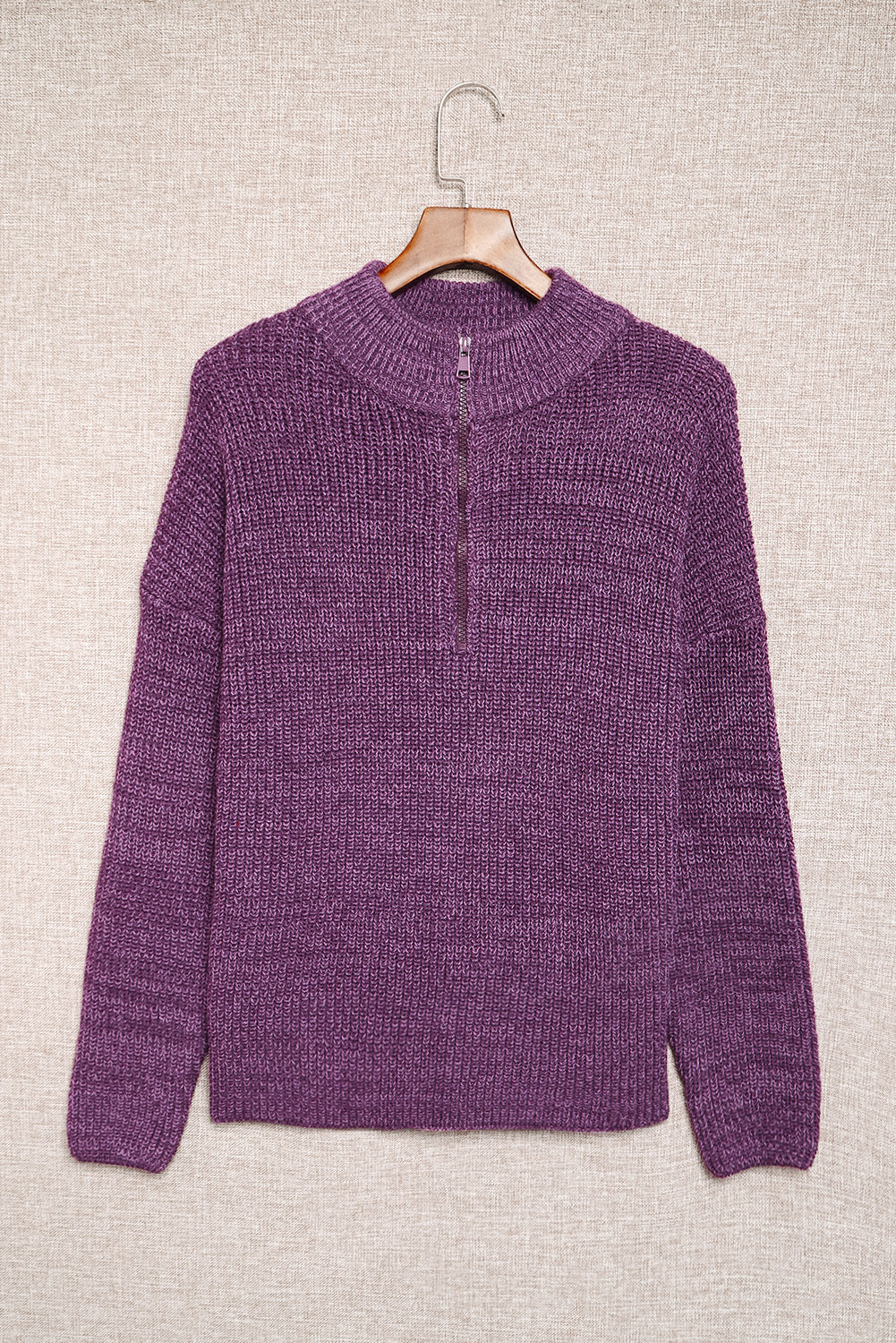 A cozy purple zipped turtleneck sweater displayed on a mannequin, showcasing its soft knitted texture and stylish design.