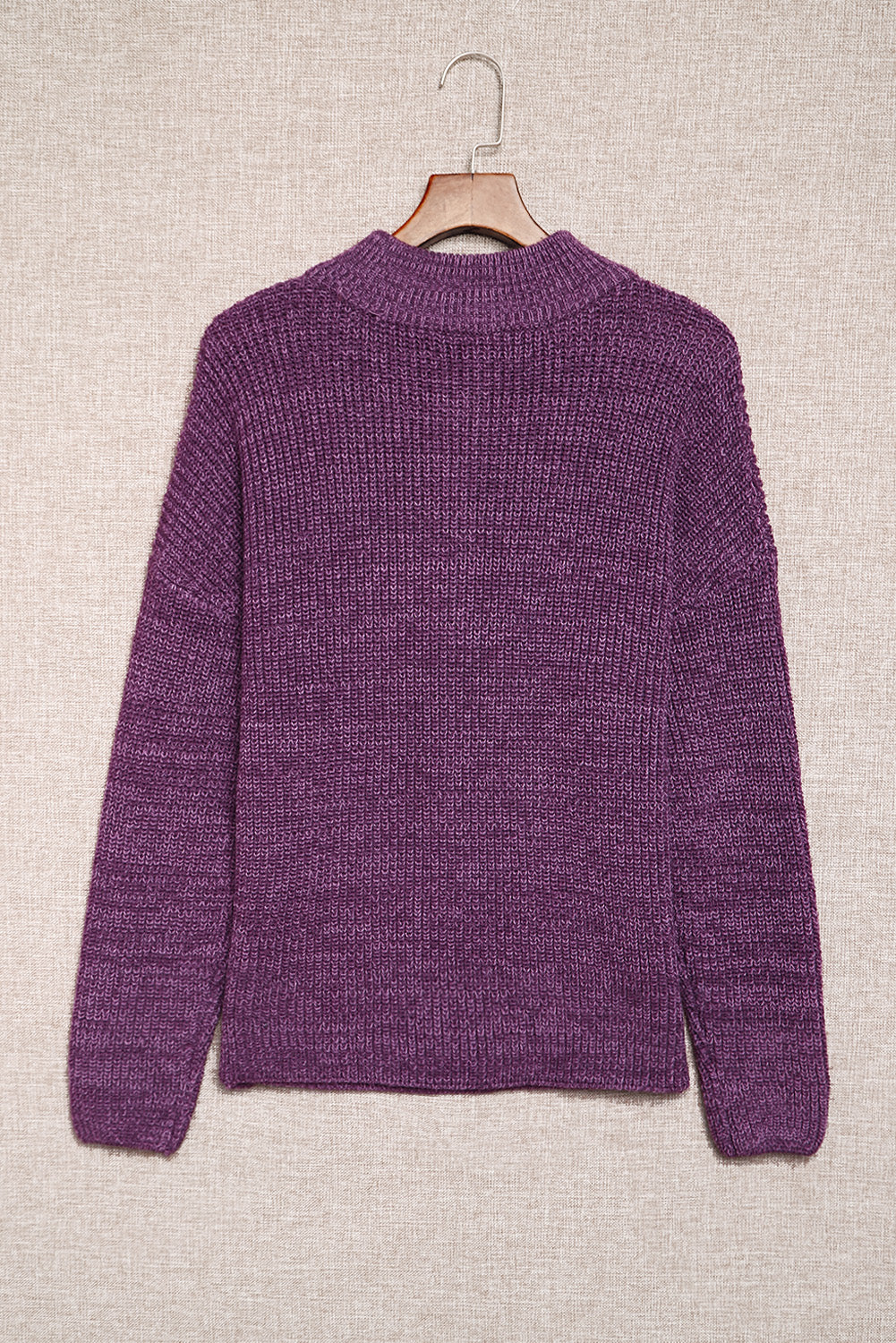 A cozy purple zipped turtleneck sweater displayed on a mannequin, showcasing its soft knitted texture and stylish design.