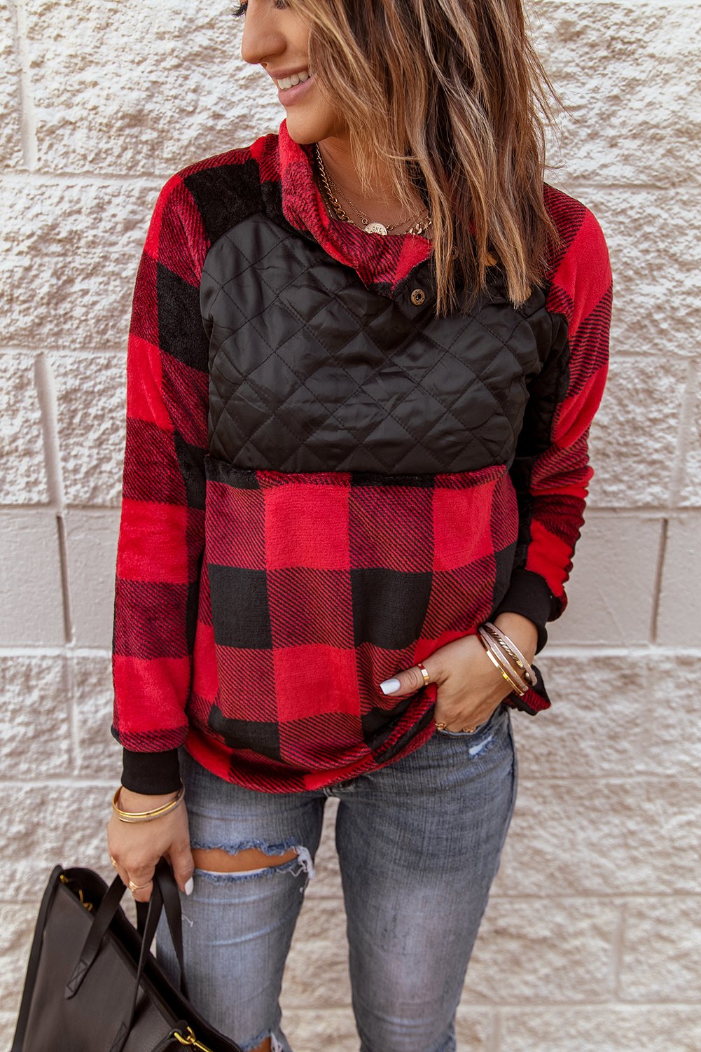 Red plaid paneled sweatshirt with asymmetric snap buttons and geometric stitching, perfect for winter wear.