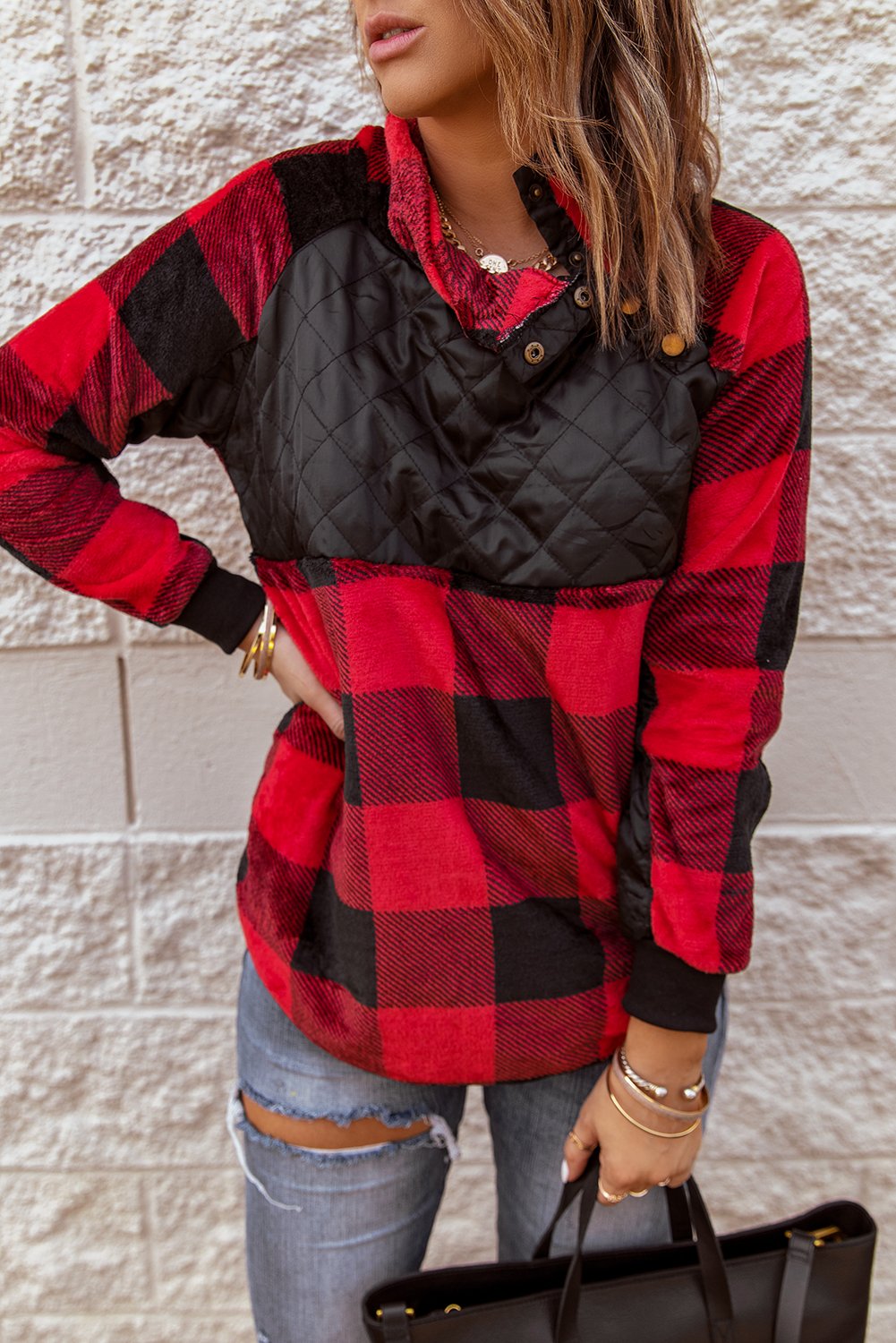 Red plaid paneled sweatshirt with asymmetric snap buttons and geometric stitching, perfect for winter wear.