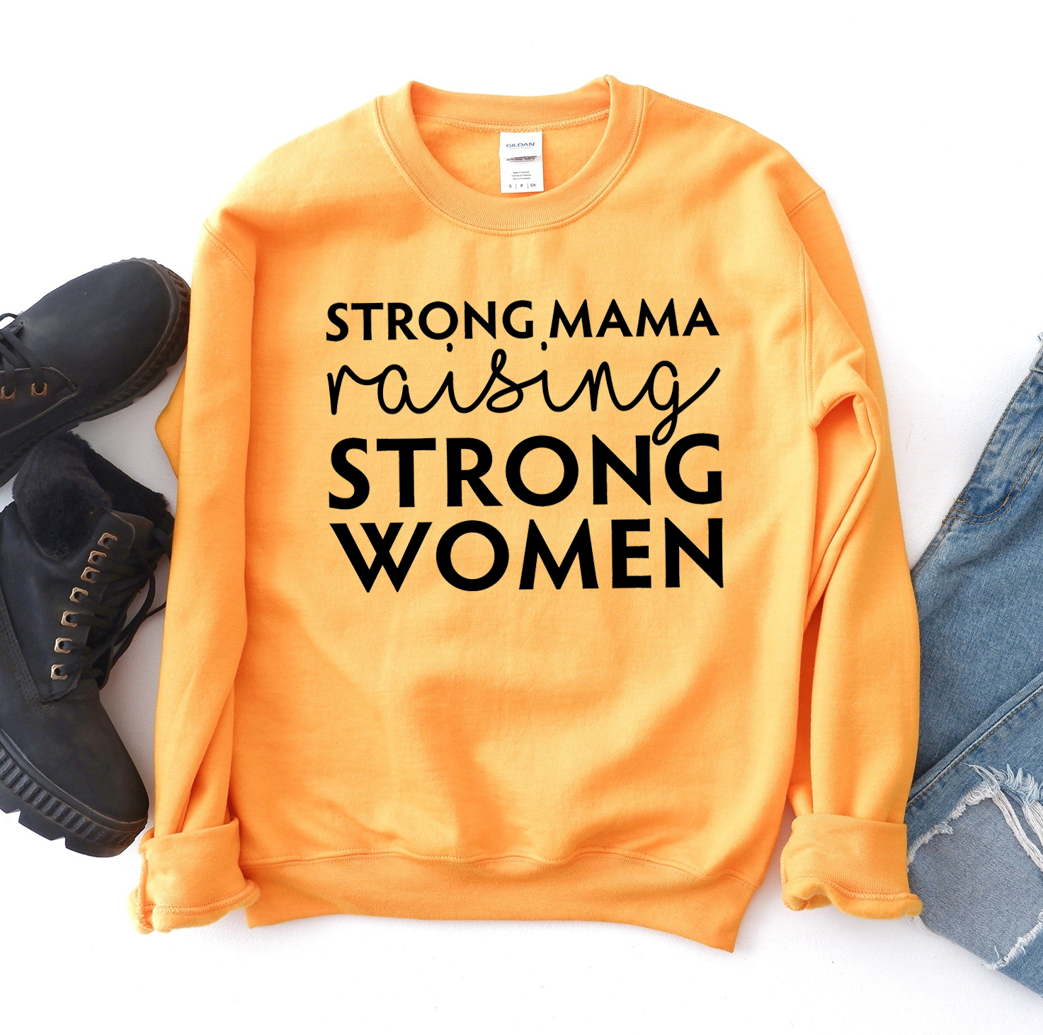 A cozy unisex sweatshirt featuring the phrase 'Strong Mama Raising Strong Women' in a stylish design, perfect for casual wear.