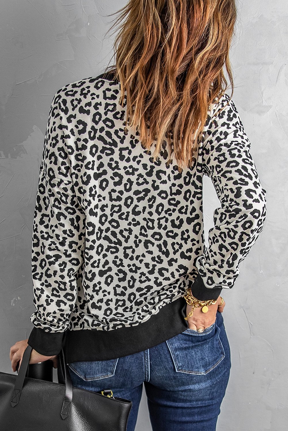 A stylish White Leopard Pullover Sweatshirt featuring an all-over leopard print design, crew neck, and side slits for a comfortable fit.