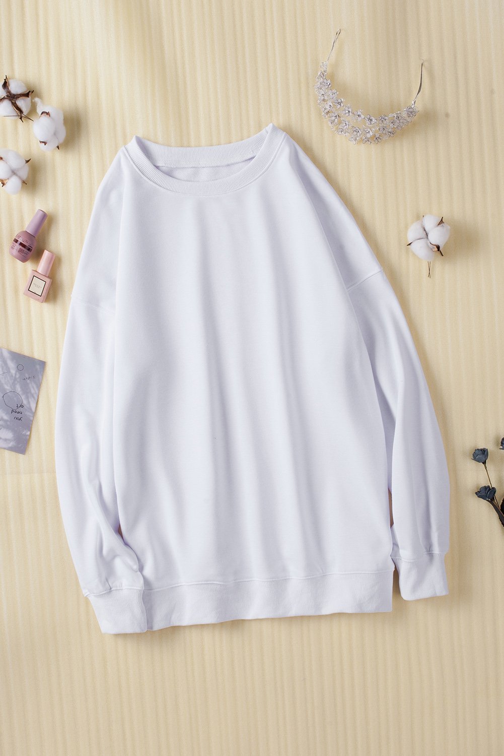 A cozy white oversized sweatshirt with a drop shoulder design, perfect for casual wear in fall and winter.