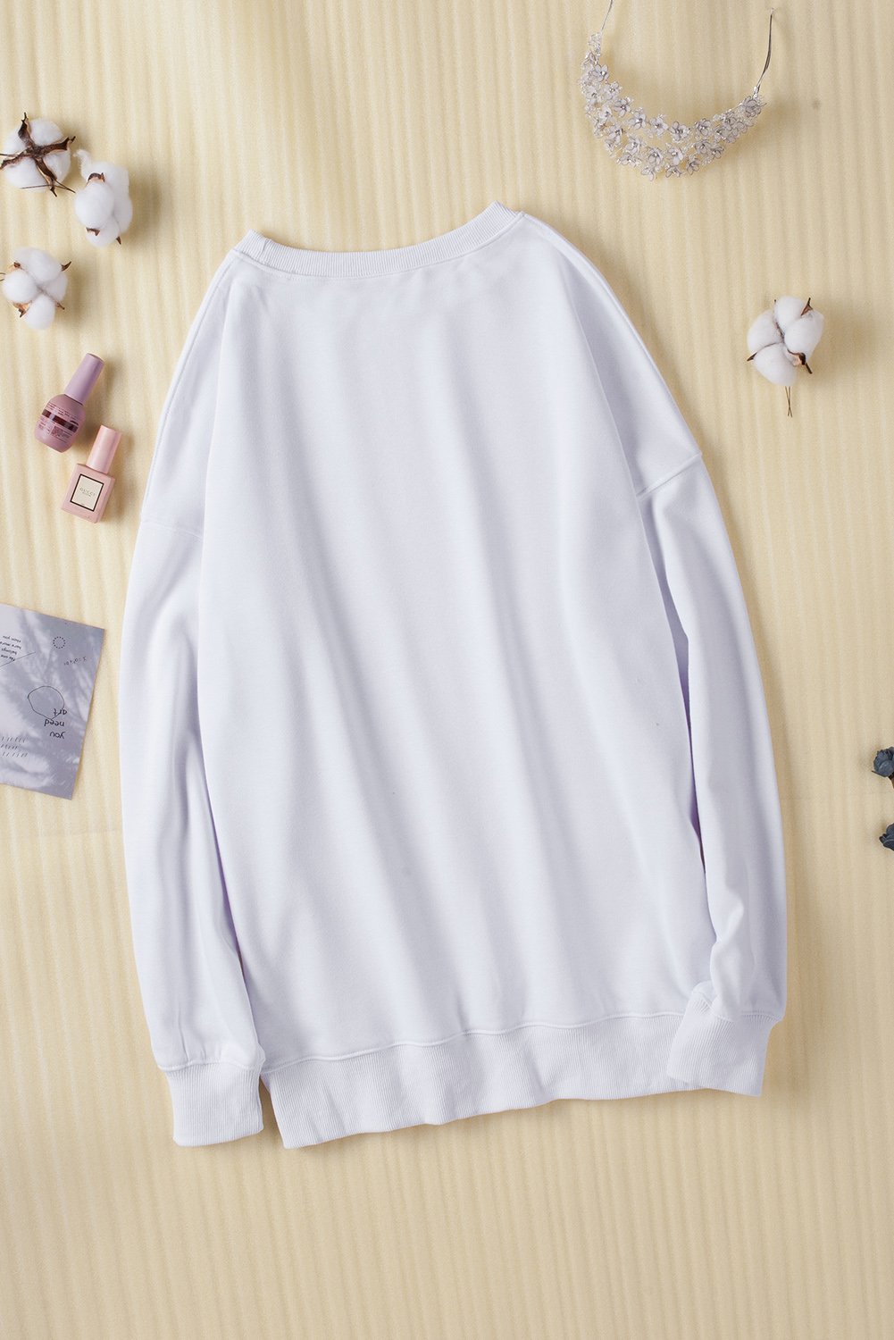 A cozy white oversized sweatshirt with a drop shoulder design, perfect for casual wear in fall and winter.