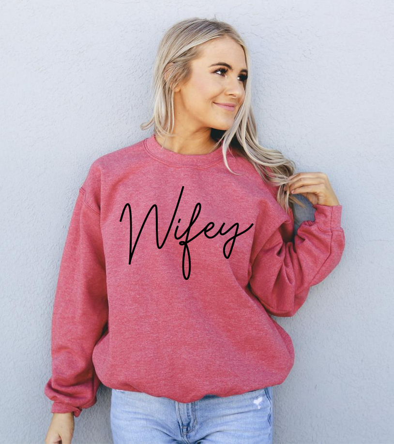 A cozy Wifey Sweatshirt in a stylish unisex design, featuring a crew neck and soft fabric.