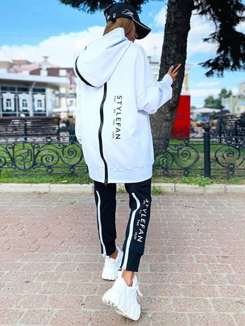 Women wearing an oversized letter print sweatshirt and ankle-length pants tracksuit set, showcasing a stylish and comfortable autumn/winter outfit.