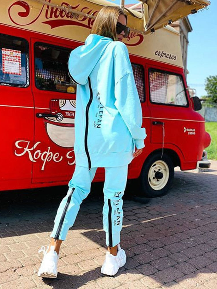 Women wearing an oversized letter print sweatshirt and ankle-length pants tracksuit set, showcasing a stylish and comfortable autumn/winter outfit.