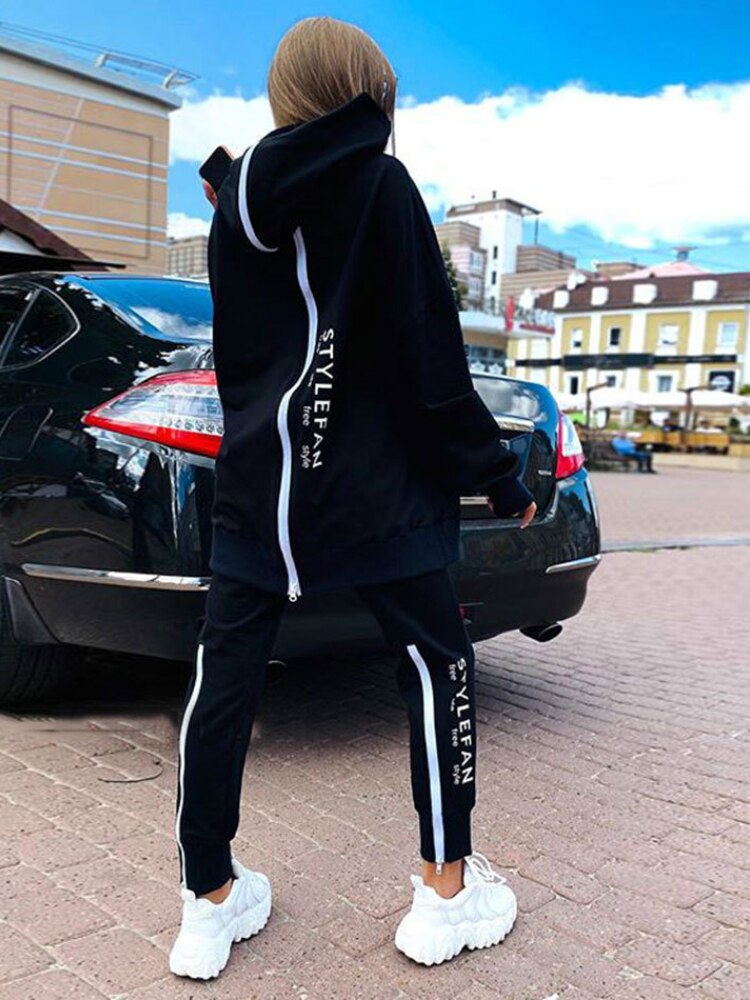 Women wearing an oversized letter print sweatshirt and ankle-length pants tracksuit set, showcasing a stylish and comfortable autumn/winter outfit.